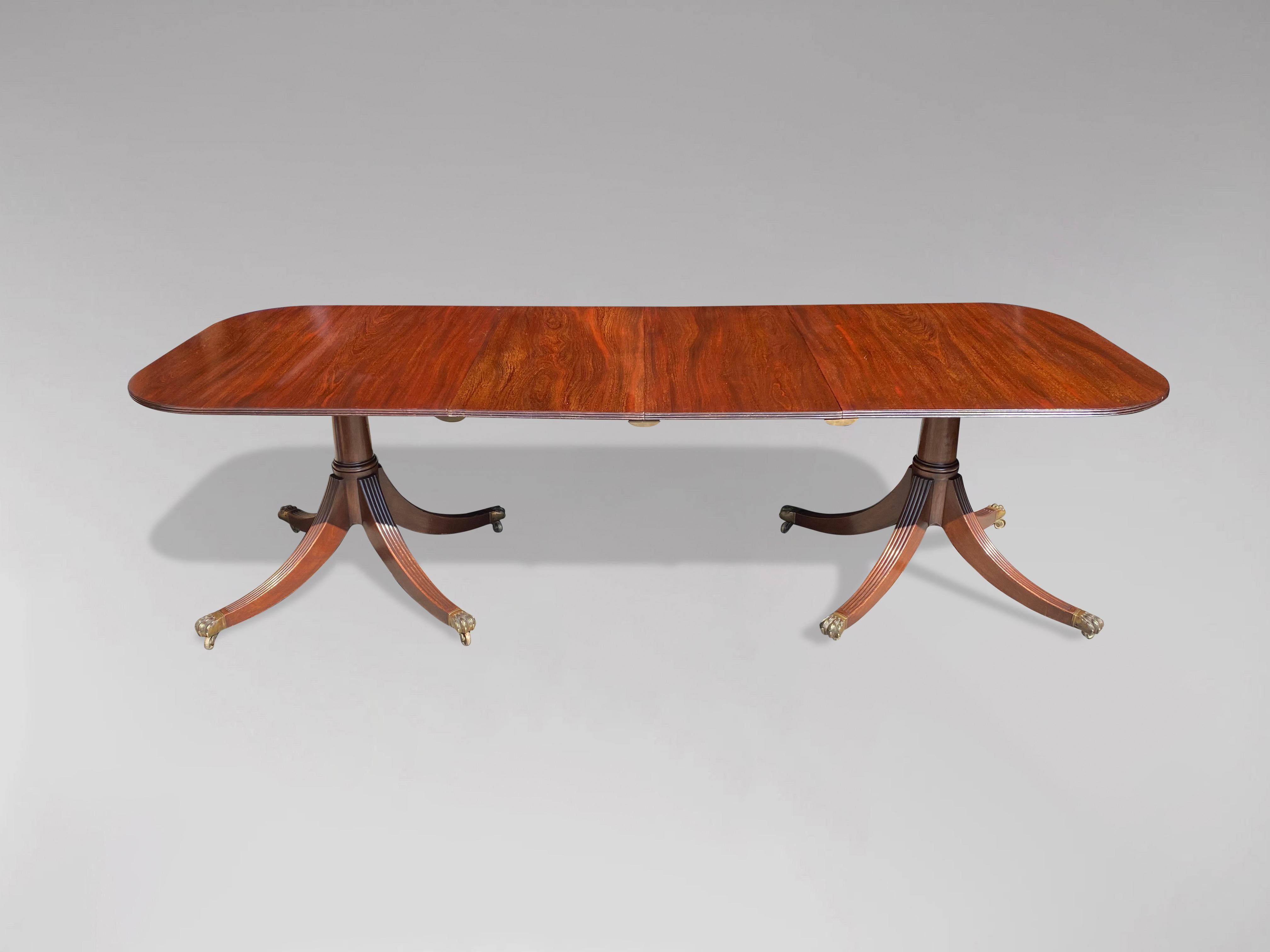 A quality early 20th century, Edwardian period solid mahogany extending dining table, with solid rounded rectangular mahogany top with reeded edge. Standing on beautiful gun barrel turned pillars with four out swept sabre reeded legs terminating in