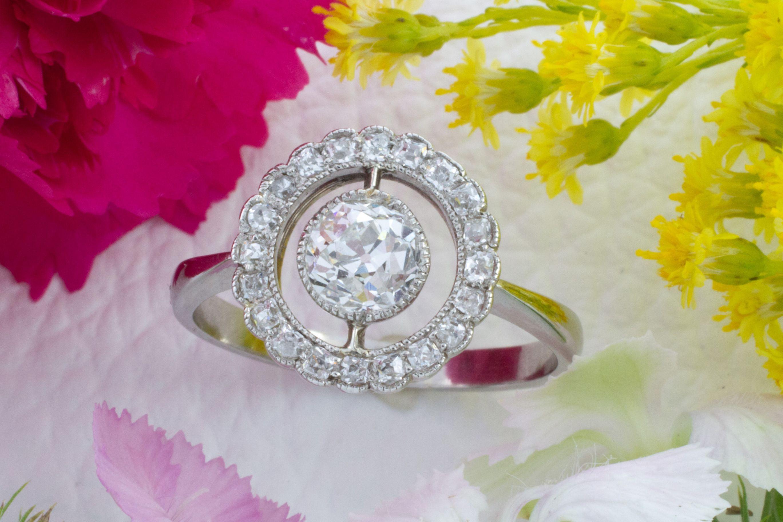 A gorgeous antique Edwardian period platinum target ring set with an old European cut diamond and 20 smaller old cushion cut diamonds in the halo. 

The old European cut is about a .60 carat stone, VS in quality and I in color. The smaller diamonds