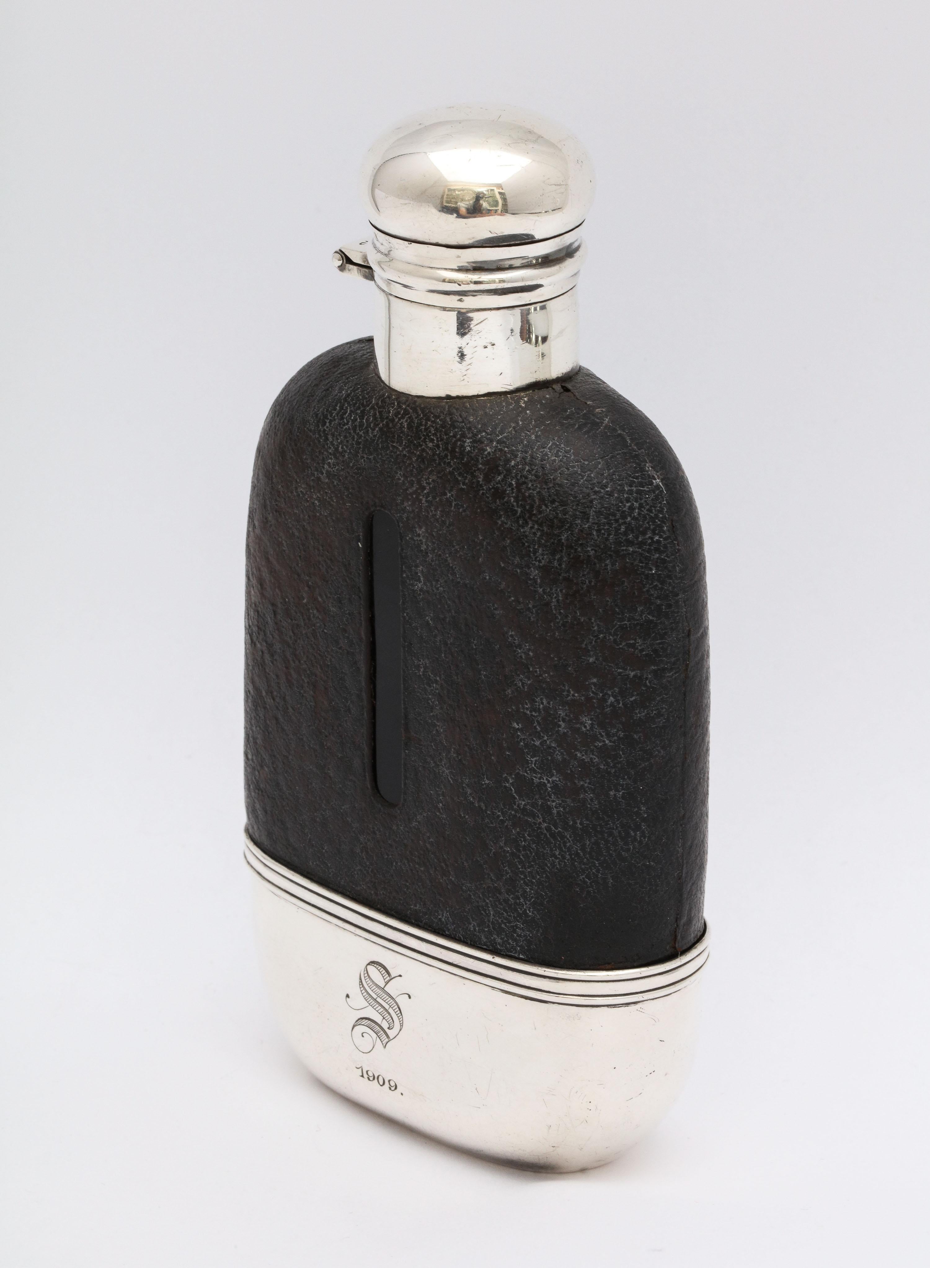 Edwardian period, sterling silver and leather-mounted glass flask, The Alvin Corp., Providence, Rhode Island, 1908. Bottom of flask, the inside of which is gilded, is removable and can be used as a drinking cup. It is monogrammed with an Old English
