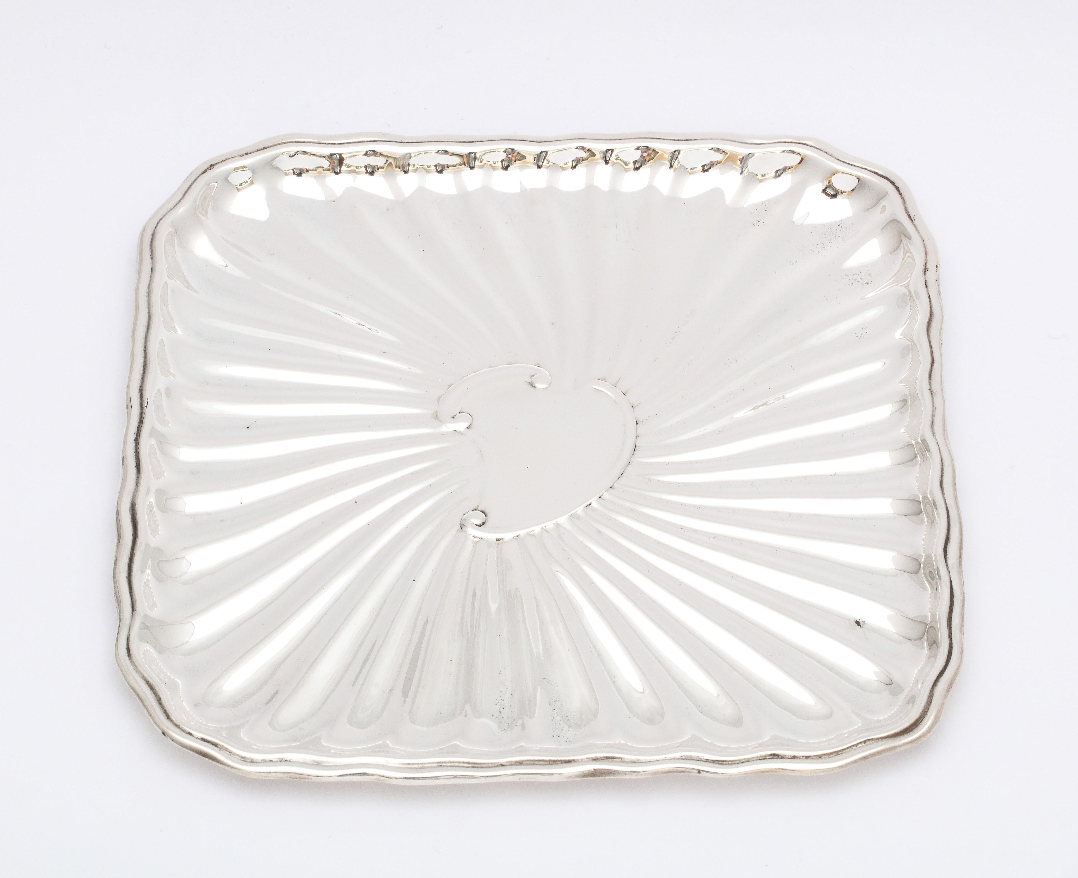 Edwardian period, sterling silver card tray, J.E. Caldwell and Company, Philadelphia, circa 1915. Fluted design. Vacant cartouche. Measures 6 1/8 x 6 1/8 x 1/4 inch high when lying flat. Weighs 4.350 troy ounces. Dark spots in photos are