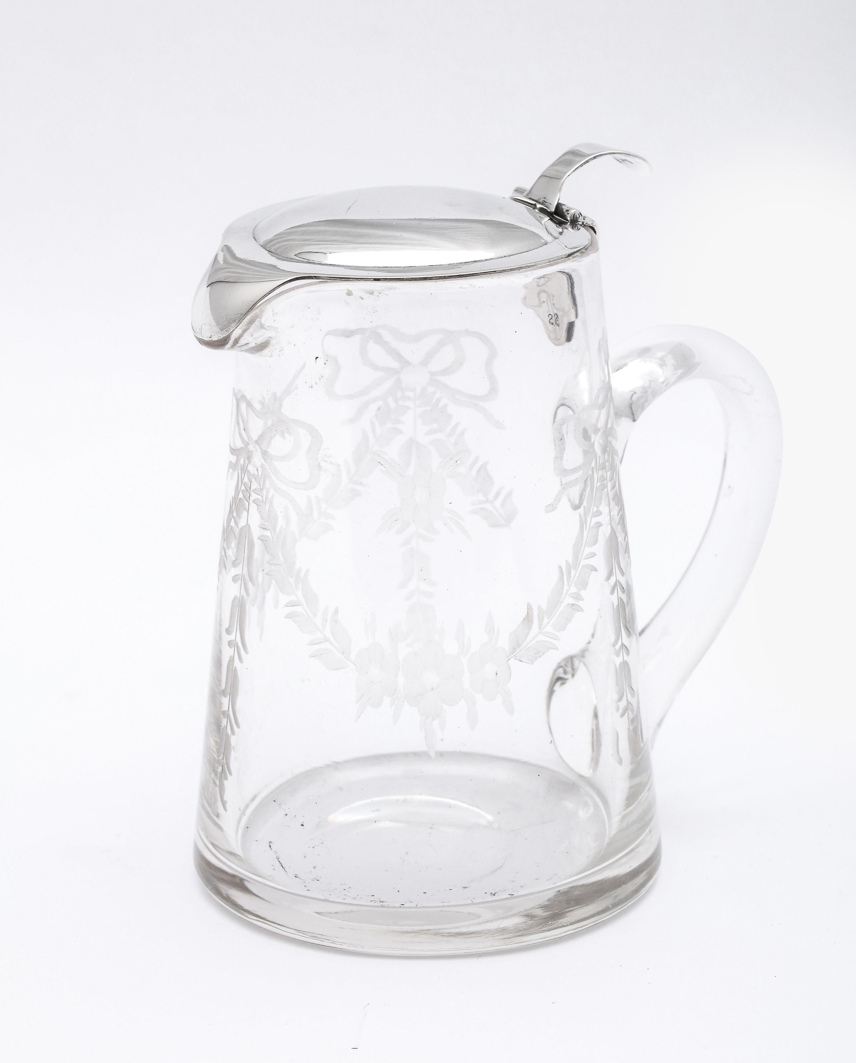 Edwardian period, sterling silver-mounted, etched glass syrup jug with hinged lid, T.G. Hawkes and Company (makers), New York, Ca. 1910. The Hawkes Company appears both on the sterling silver lid and is etched into the underside of the jug itself
