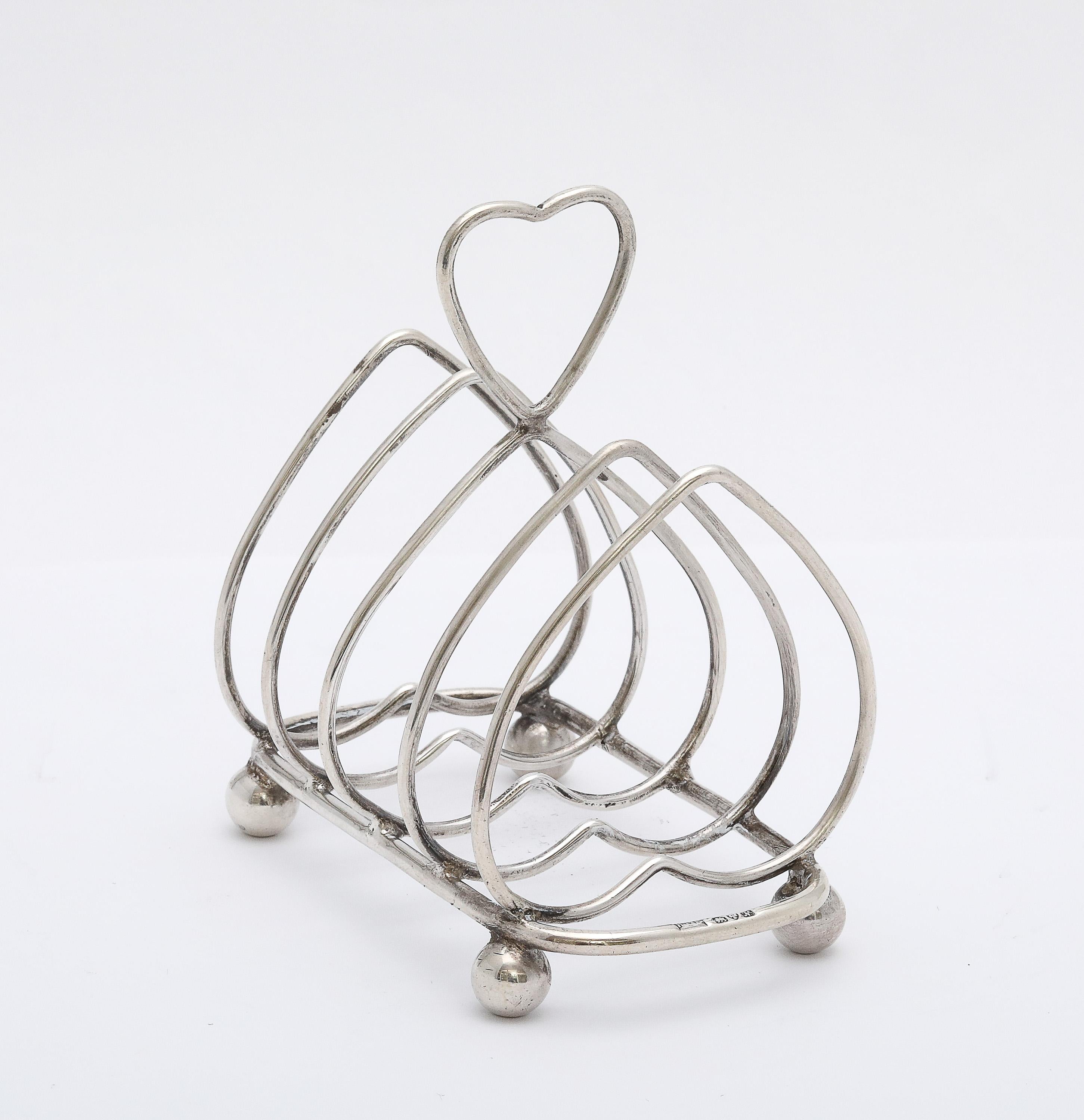 Période édouardienne, style Art nouveau, inhabituel, en argent sterling, porte-tartines en forme de cœur sur pieds ballons, Chester, Angleterre, année poinçonnée pour 1913, Herbert Edward Barker (of Barker Brothers) - fabricant. Chacune des sections