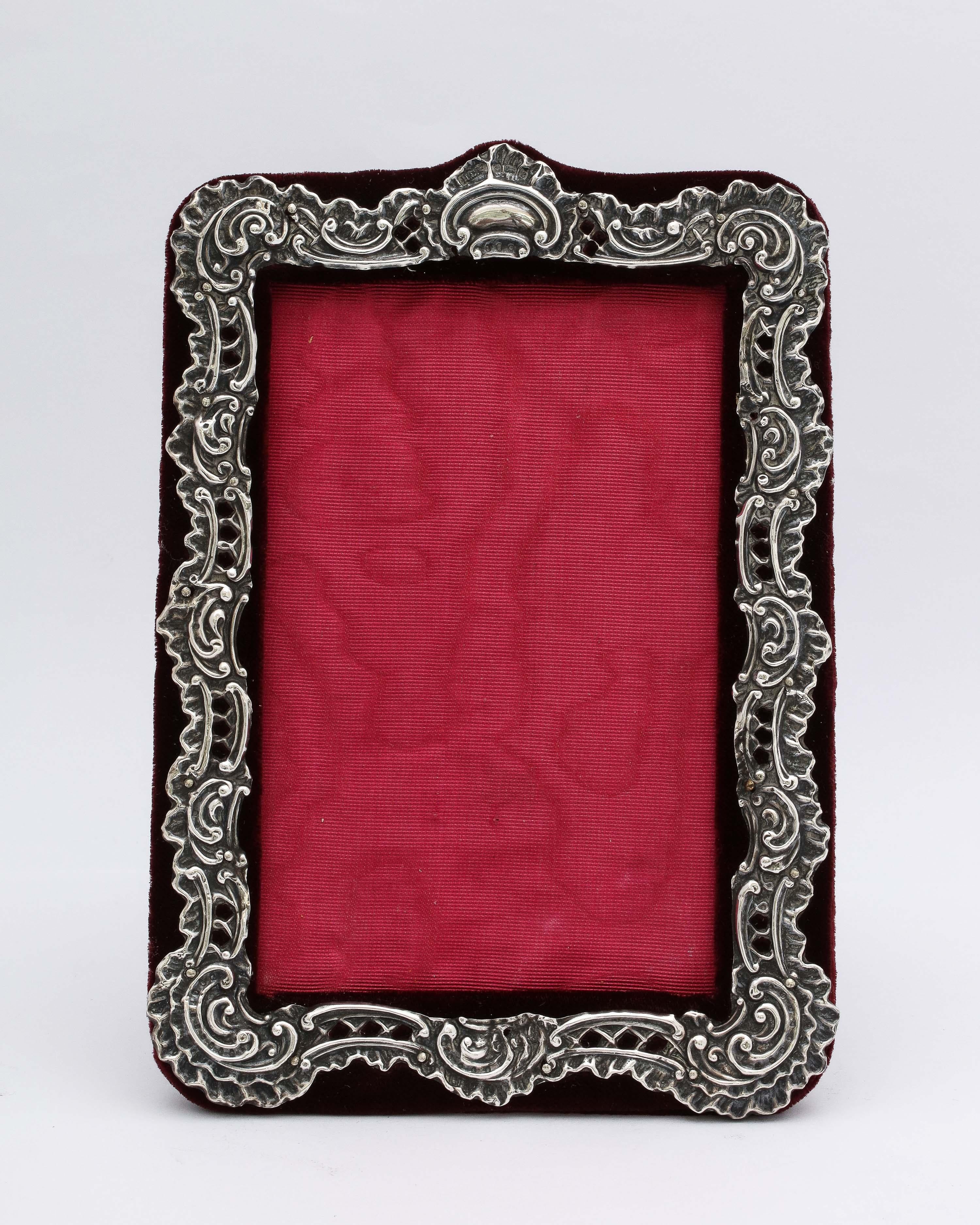 Edwardian Period sterling silver picture frame (in the Victorian style), Birmingham, England, year-hallmarked for 1902, Charles Henry Freeman - maker. Sterling silver is pierced and mounted on burgundy velvet. The piercing allows the velvet to show