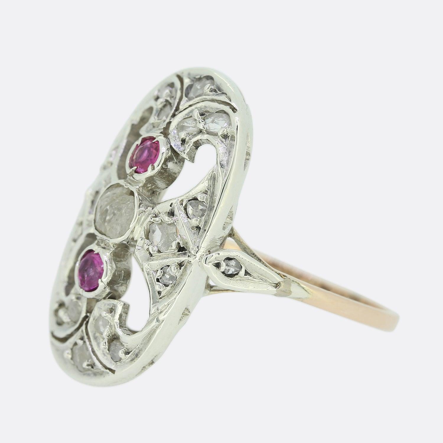 This is a lovely Edwardian pink sapphire and diamond ring. It features a central rose cut diamond with a pink sapphire set above and below and surrounded by a border of more rose cut diamonds in an oval shaped setting. The navette ring has been