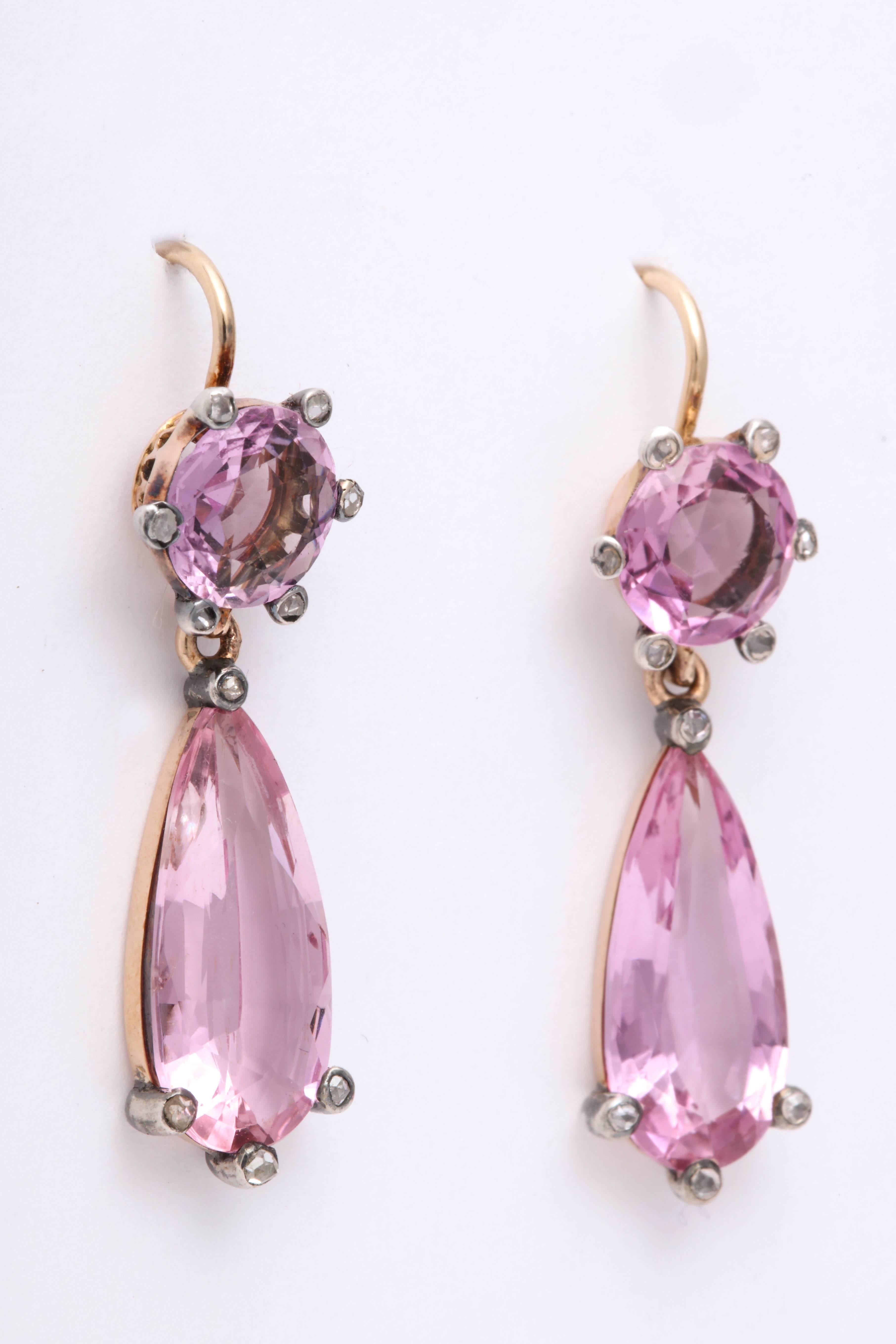 English dangle drop earrings with the most vibrant pink topaz in yellow gold. 10 small rose cut diamonds are set in silver on each earring. 