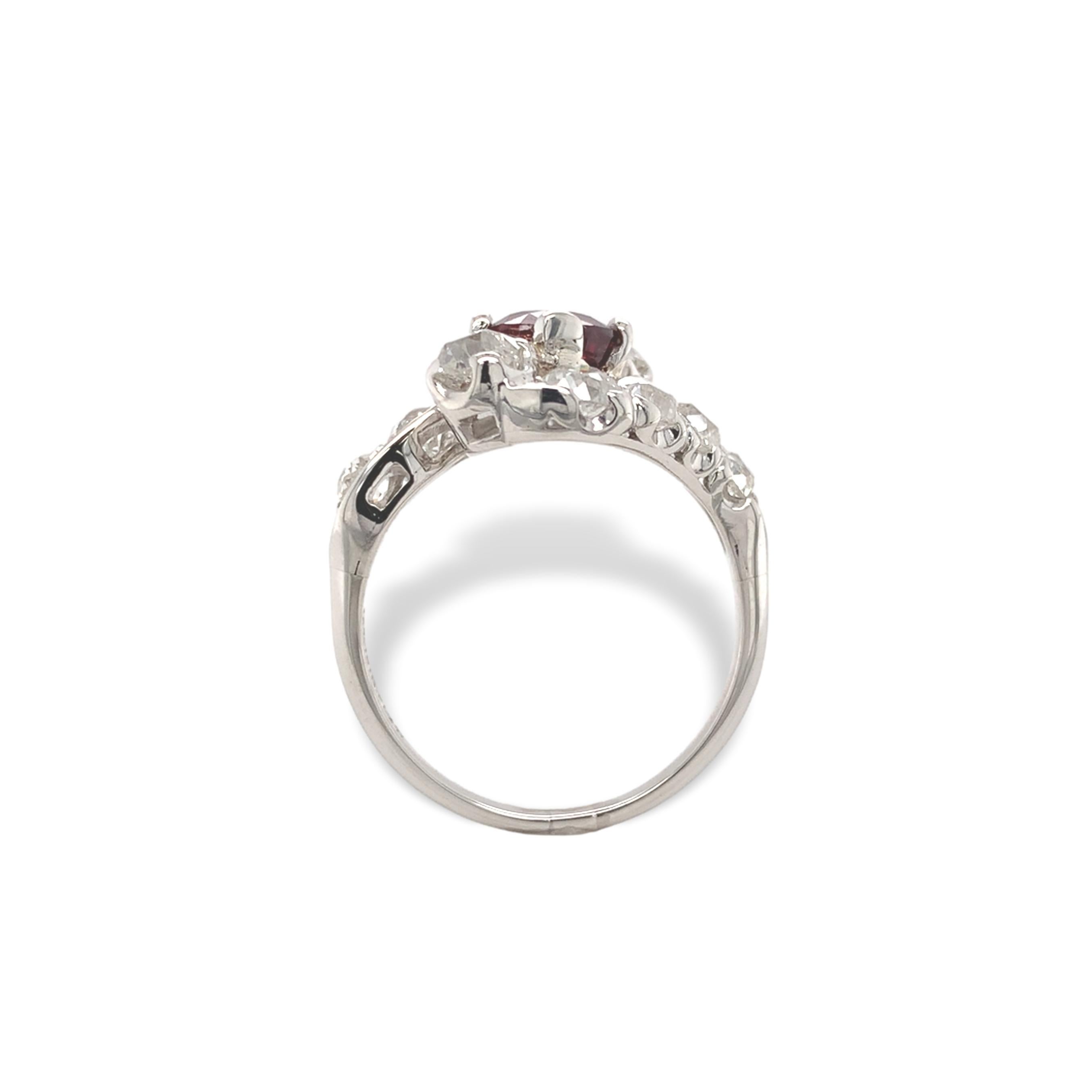 Edwardian platinum red spinel and mine cut diamond ring. The oval  blood red natural spinel weighs 1.29 carats and measures about 6.5mm x 5.8mm. The spinel is set with 4 new prongs. There are 10 round diamonds, 9 mine cut and one European cut