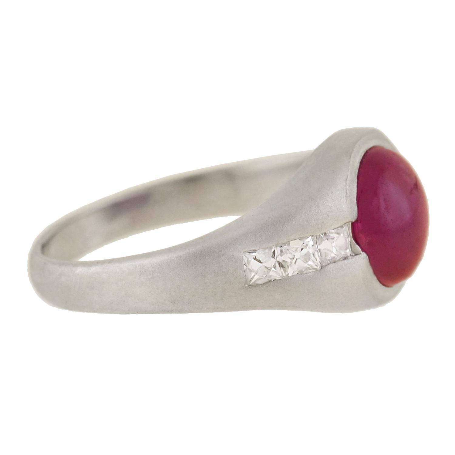 A gorgeous ruby and diamond ring from the Edwardian (ca1910) era! Crafted in platinum, this stylish piece features a stunning Burmese ruby cabochon at the center. The luscious stone displays a natural raspberry red color, and is nestled between a