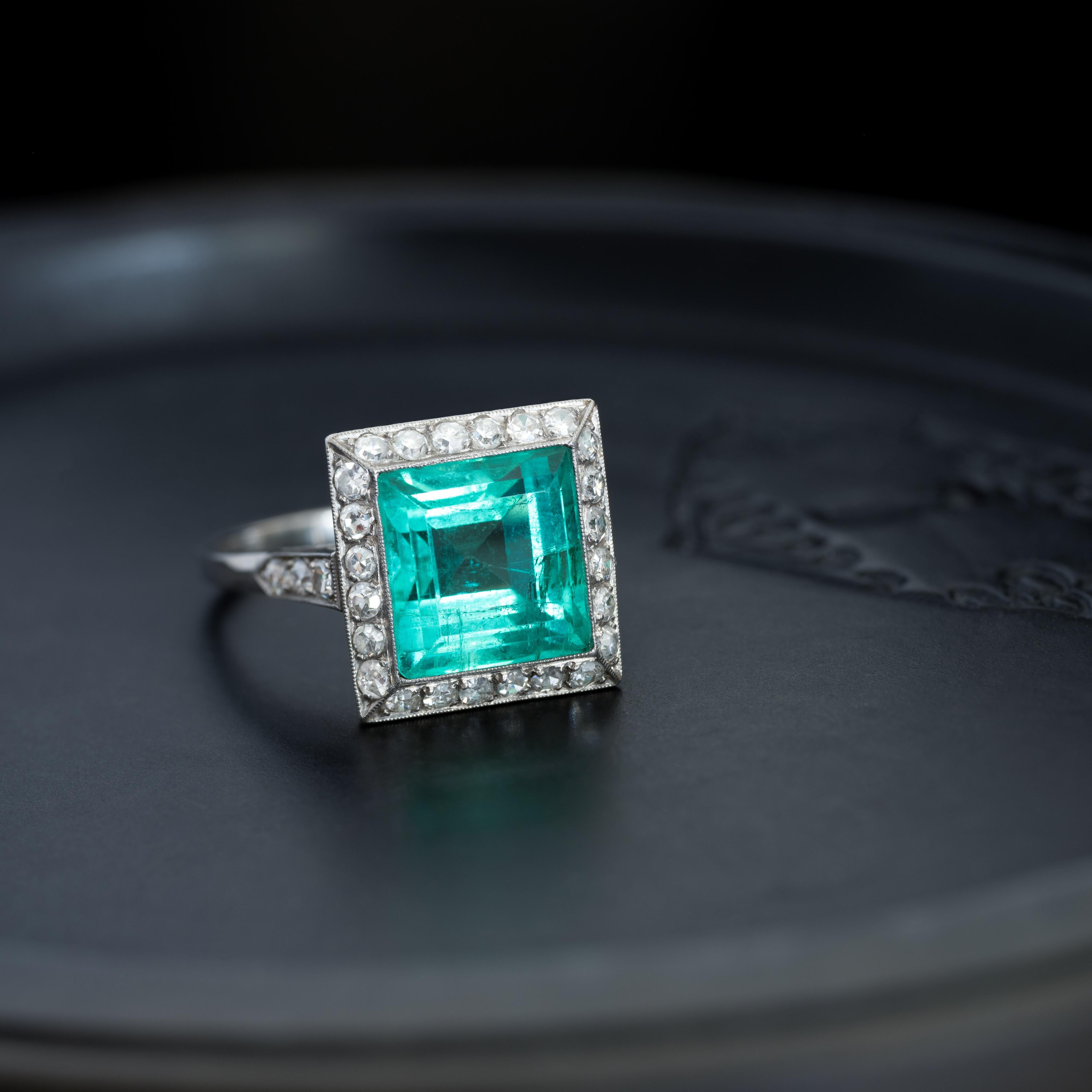 Esmeralda colombiana cuadrada talla escalonada de platino eduardiana de 6,50 ct y halo de diamantes talla europea antigua de 0,40 ct 
c.1925 
talla 6

Un anillo especial, impresionante y único en su especie. Es muy raro encontrar una Esmeralda