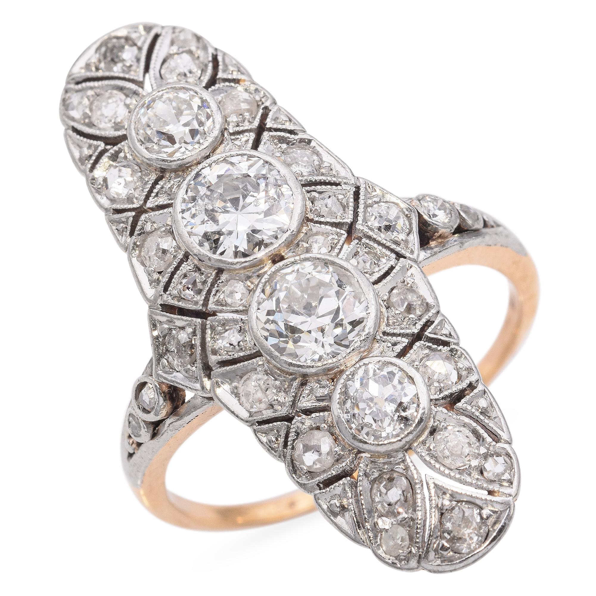 This stunning Edwardian-era platinum and 14K yellow gold diamond knuckle duster ring is a true statement piece. Designed with intricate craftsmanship, it features a bold arrangement of sparkling diamonds set in platinum, gracefully contrasted by the