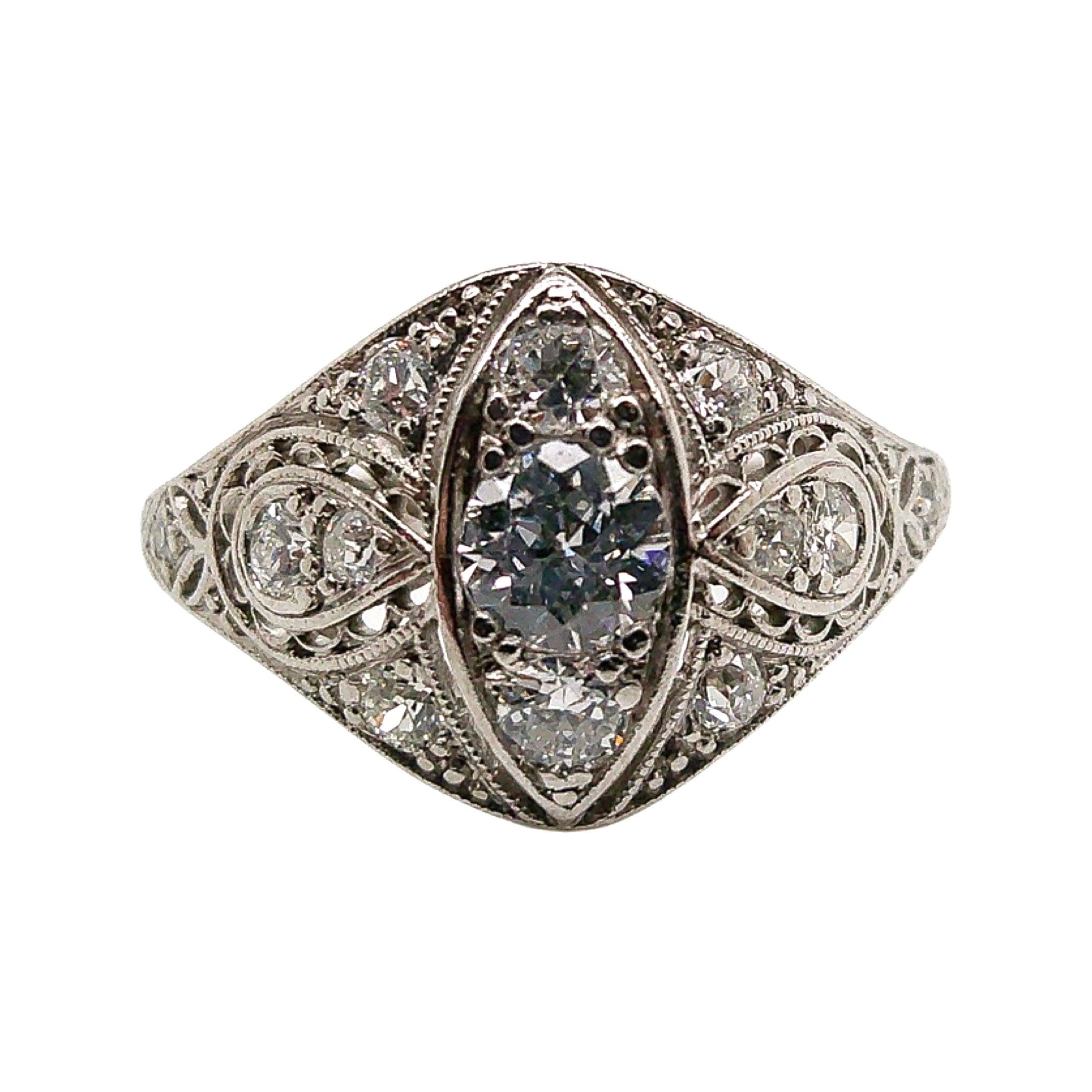 This antique piece was handcrafted sometime during the Edwardian design period (1900-1920). Delicately crafted in exquisite platinum, this whimsical ring captures the essence of the Edwardian period with its timeless beauty and intricate details.
