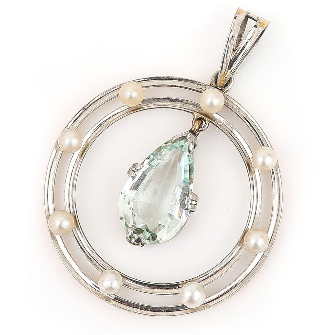 Dating from the Edwardian era circa 1910 this beautiful pendant is set in platinum on 9ct gold with a tear drop aquamarine and pearls. The central claw set, tear drop aquamarine is full articulated and is surrounded by a double circle frame upon