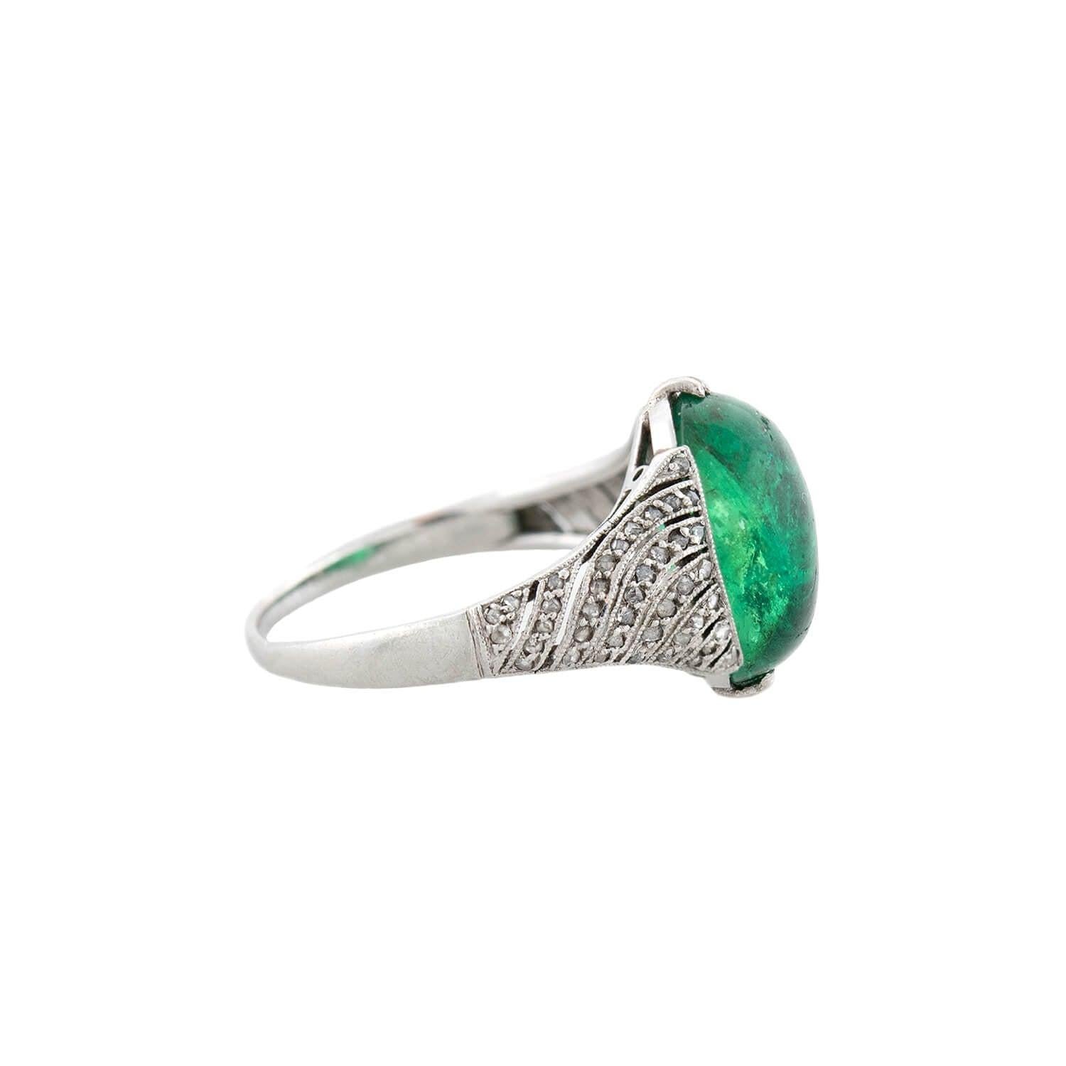 An impressive ring from the Edwardian (ca1910s) era! Crafted in platinum, this ring adorns a mesmerizing green emerald cabochon! The oval-shaped stone is of Columbian origin and exhibits beautiful, vibrant shades of green, held within a unique