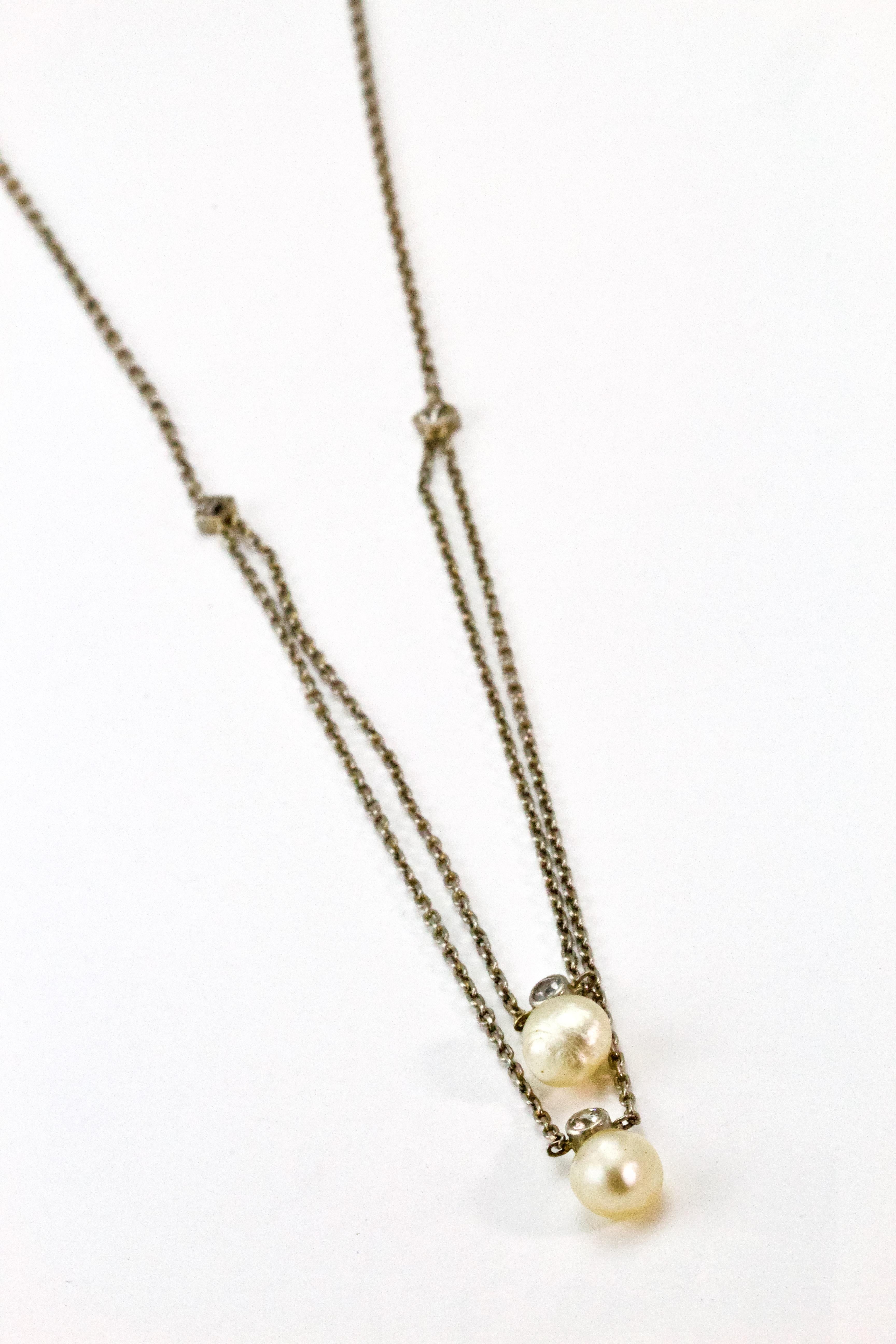 Collier Edouardien en platine à double rang avec des diamants taillés à la mine ancienne et deux perles naturelles. La chaîne est en platine, de 1,5 mm, avec un fermoir à pression en forme de barillet. Chaque perle est délicatement suspendue à un
