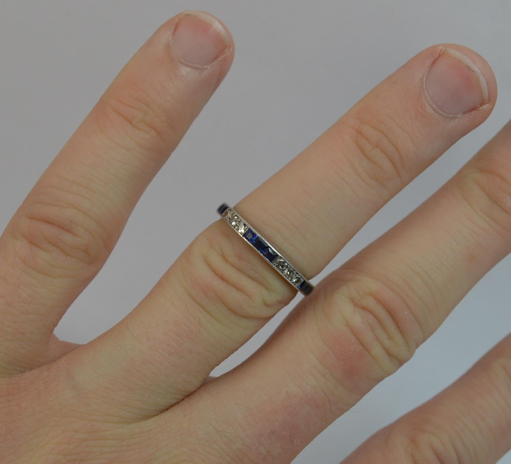 A stunning ladies full eternity ring. Solid platinum ring. Set with princess cut natural sapphires stones and round cut diamonds in lots of 3's. 2.2mm thick band throughout, protruding 1.65mm off the finger. Grain setting to the front throughout.