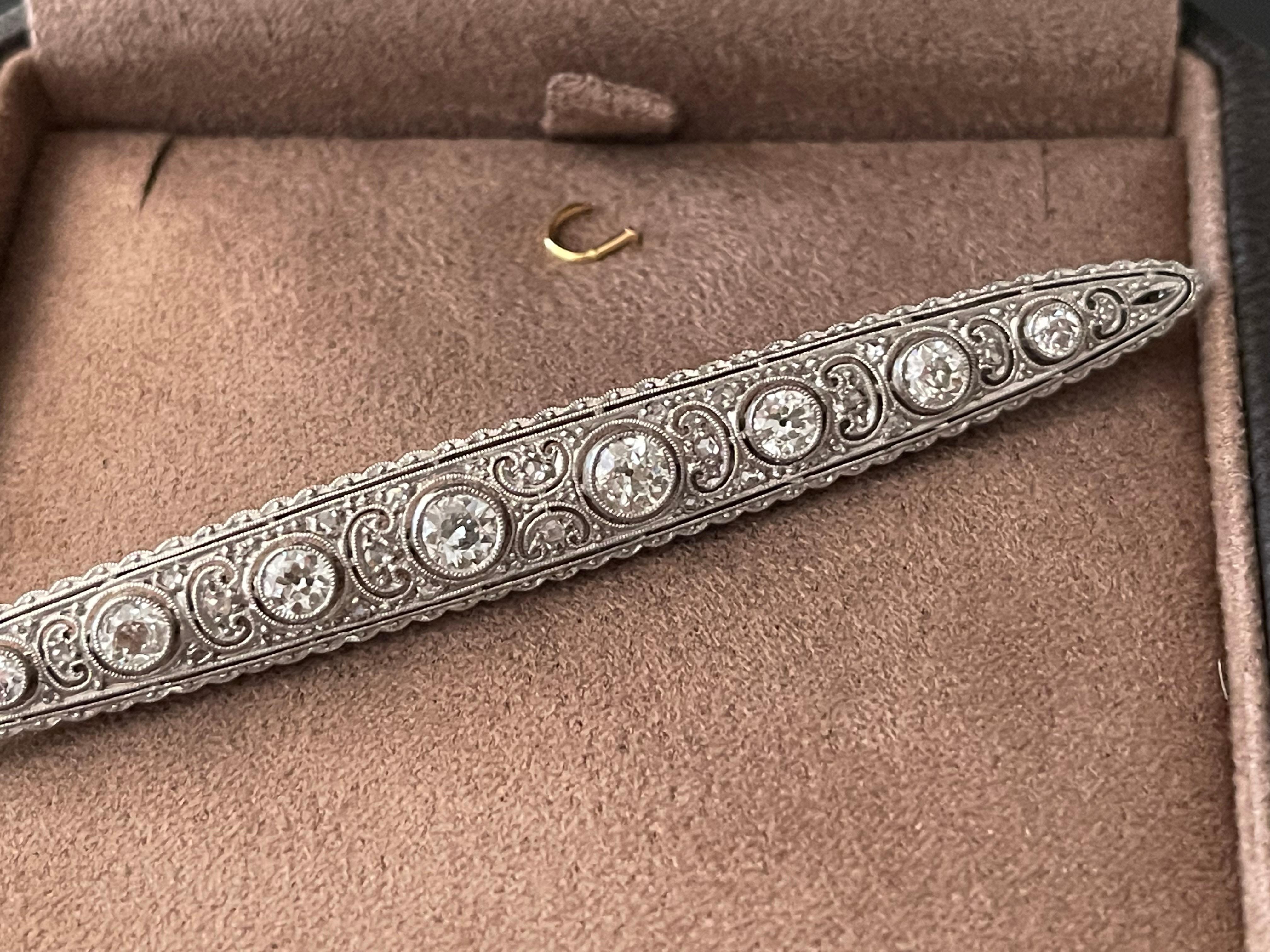 A very fine and elegant Platinum Diamond Edwardian bar pin brooch.

The fine filigree brooch has a 8 larger round brilliant  cut diamonds at its center that is flanked by horizontal stylized motifs with diamonds, fine milgrain. Total diamond weight