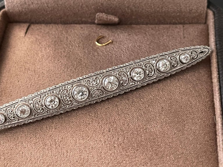 A very fine and elegant Platinum Diamond Edwardian bar pin brooch.

The fine filigree brooch has a 8 larger round brilliant  cut diamonds at its center that is flanked by horizontal stylized motifs with diamonds, fine milgrain. Total diamond weight