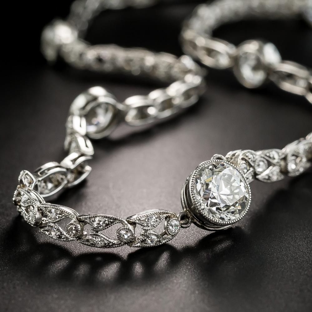 This breathtaking, exquisitely designed and executed Belle Époque choker necklace is comprised of beautifully articulated open diamond-set links, punctuated every so often with tiny flower links, centering a bright-white radiant bezel-set