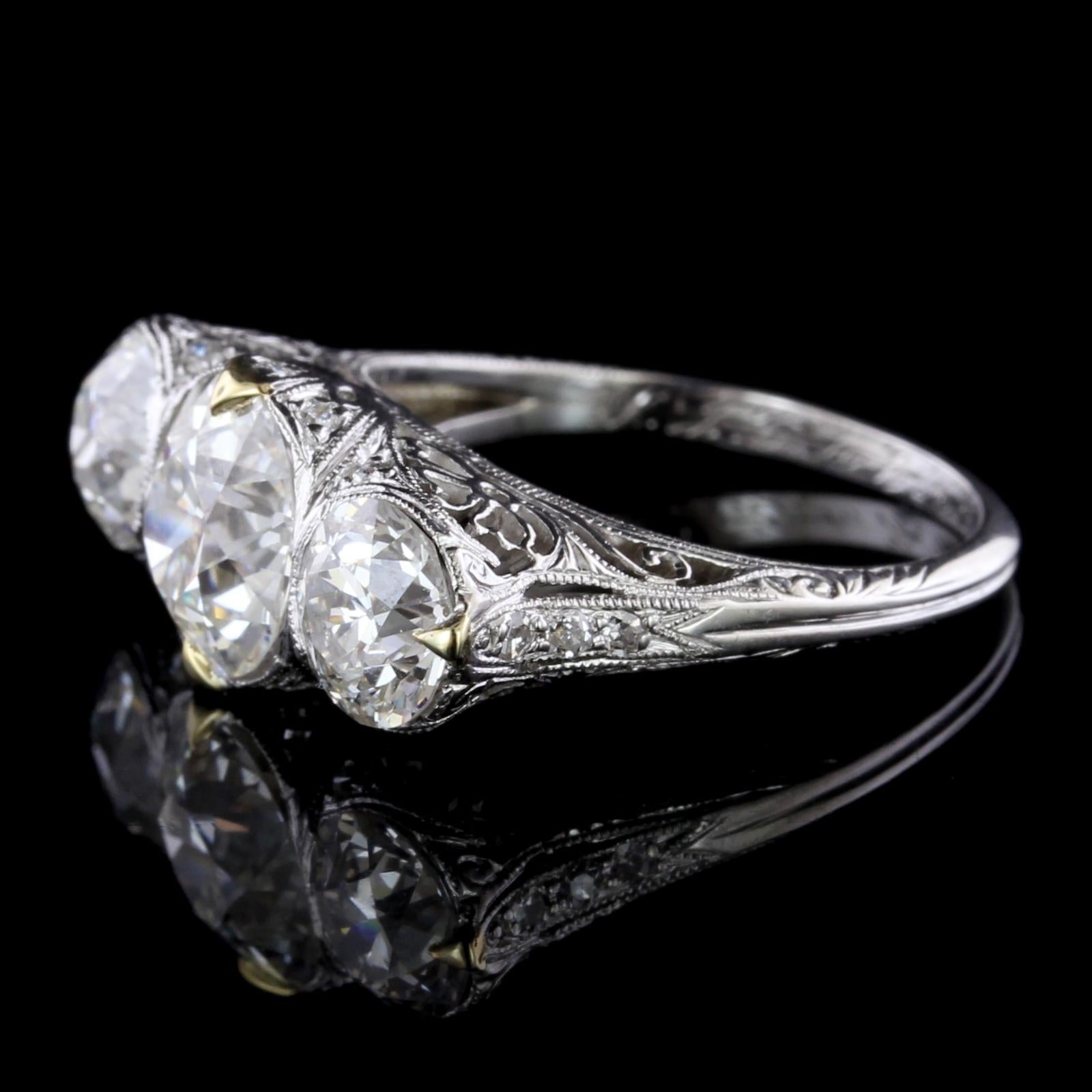 Edwardian Platinum Diamond Three Stone Ring. The ring is set with one old
European cut diamond weighing 1.94cts., I color, VS1 clarity, GIA #1196513406, one old European
cut diamond weighing .89cts., H color, VS2 clarity, GIA #2193513638, and one