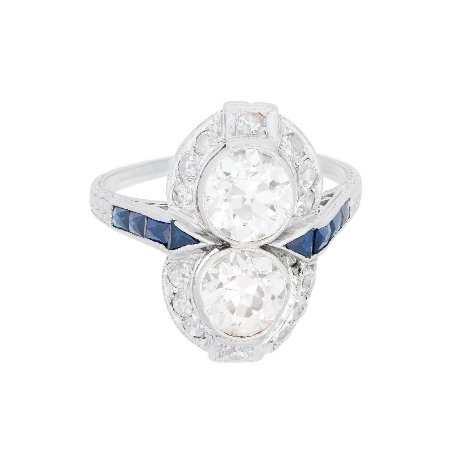 Uno splendido anello con diamanti e zaffiri dell'epoca edoardiana (ca. 1910)! Questo bellissimo anello è realizzato in platino e presenta due diamanti centrali taglio old mine che corrono verticalmente lungo il centro dell'anello. I diamanti sono