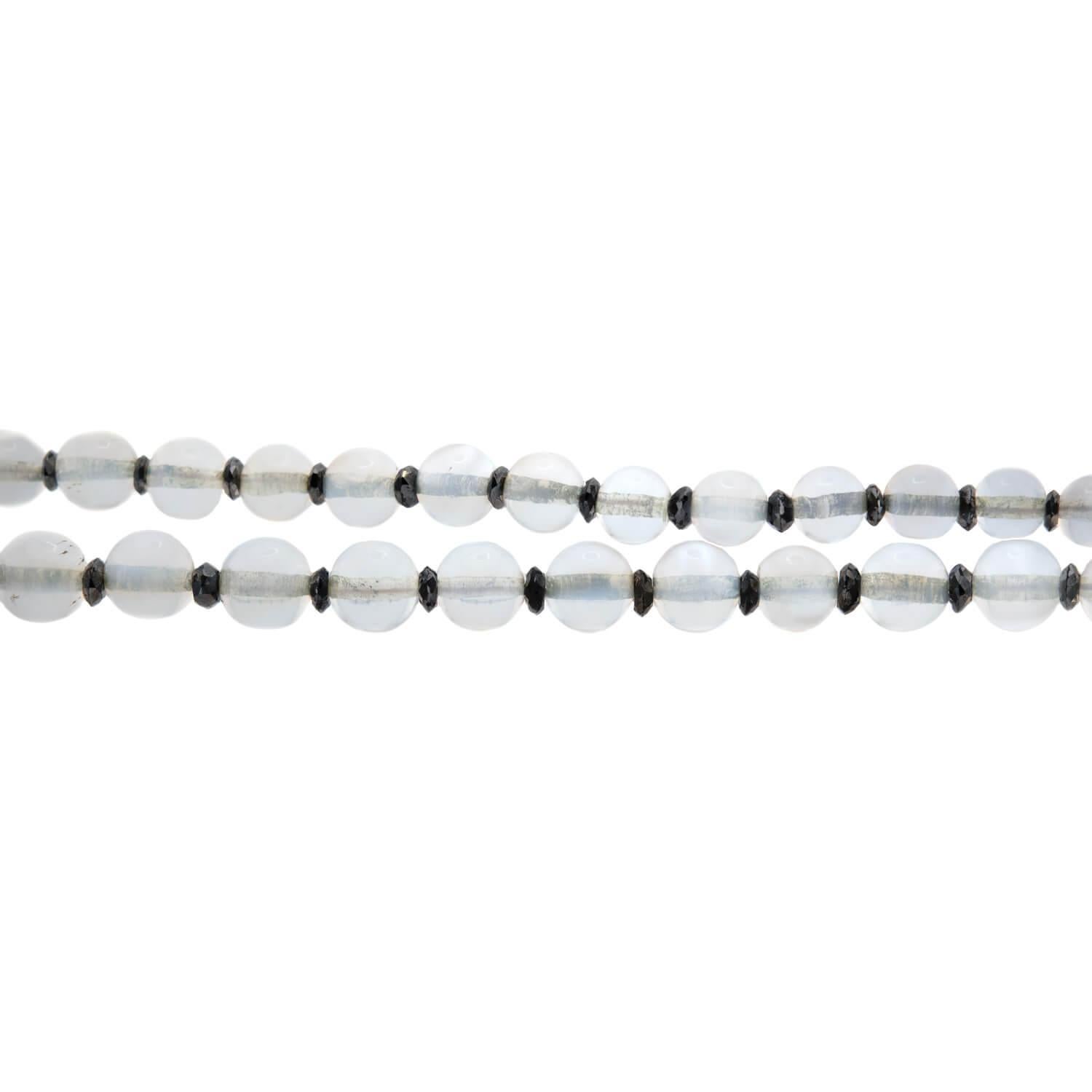 Un magnifique collier de perles en pierre de lune et en diamant de l'époque édouardienne (vers les années 1910) ! Réalisé en platine, ce collier est composé d'une alternance de perles rondes en pierre de lune et de rondelles de diamant noir. Les