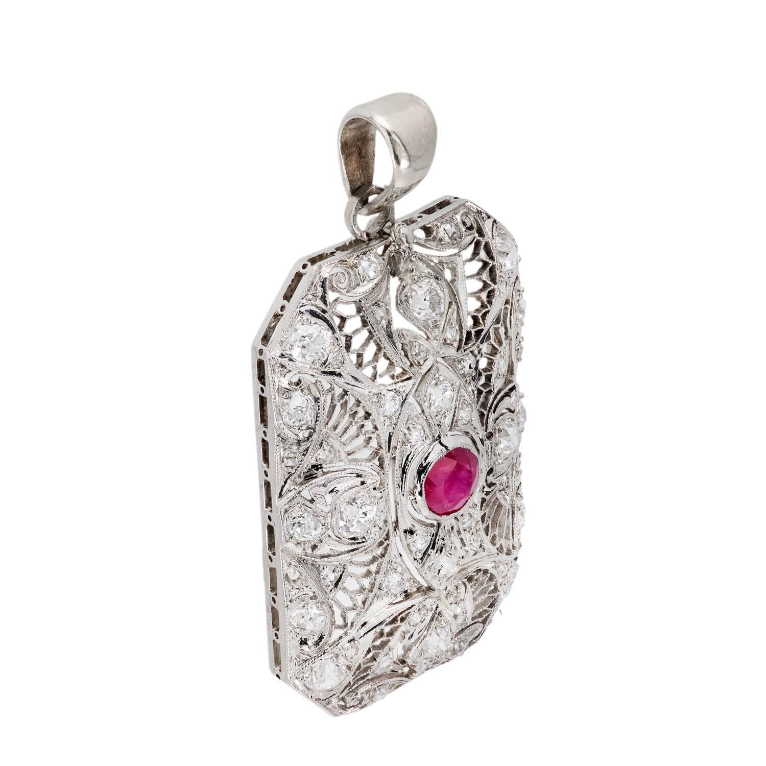 Uno splendido ciondolo con rubino e diamante di epoca edoardiana (ca. 1910)! Realizzato in platino, questo ciondolo di forma rettangolare presenta un rubino centrale di 1,25 carati a taglio rotondo, racchiuso in un castone a grana fine. Il rubino è