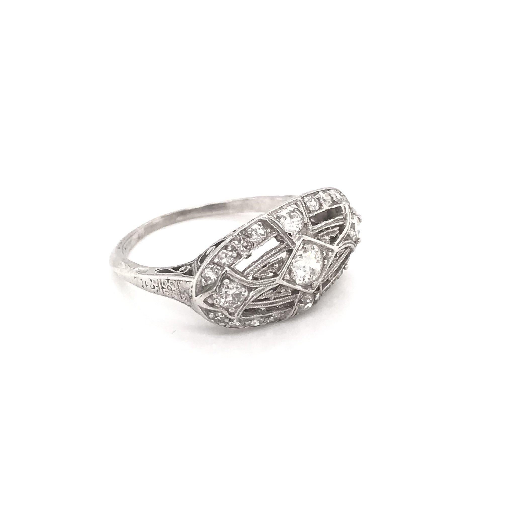 This antique piece was handcrafted sometime during the Edwardian design period ( 1900-1920 ). This stunning filigree ring features approximately 0.50 carats of diamonds. Three central diamonds are prominent, set east to west, as well as a shimmering