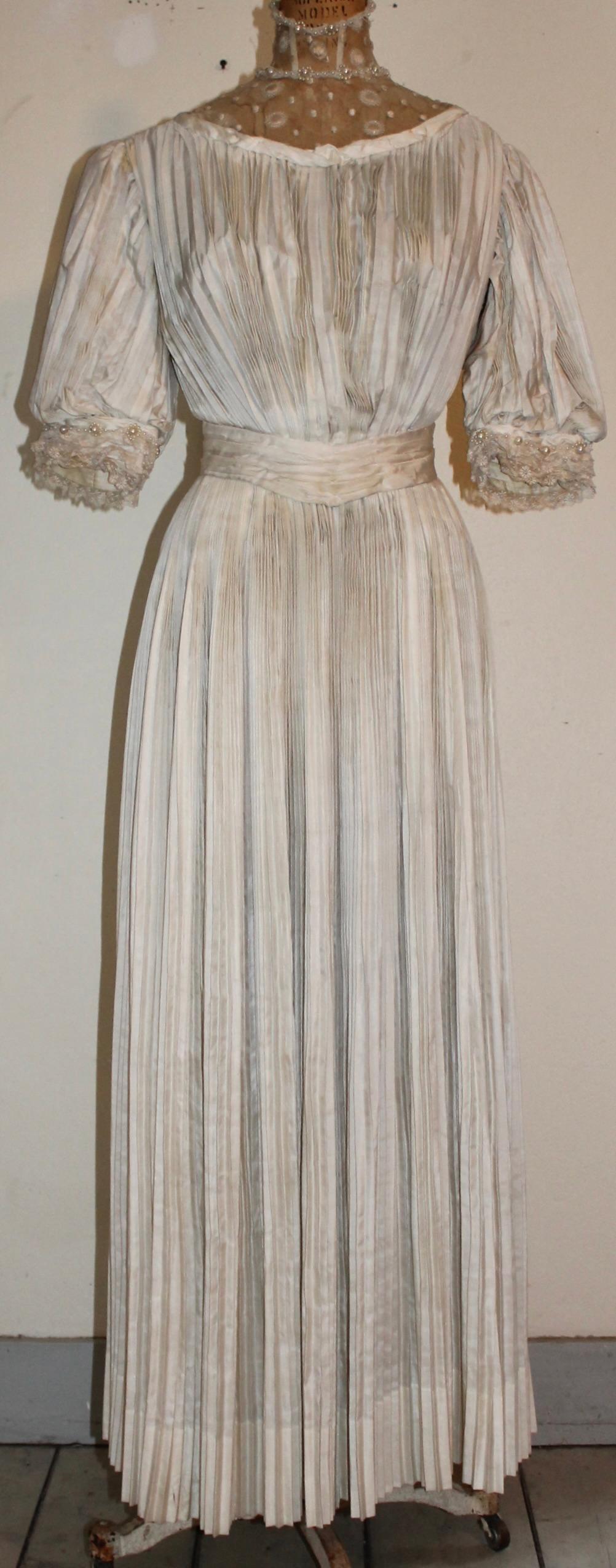 Vestido de té o de novia eduardiano de seda crema plisada larga a la manera de Fortuny. Con cinturón de seda adjunto. Cuello y puños de encaje con perlas de imitación.