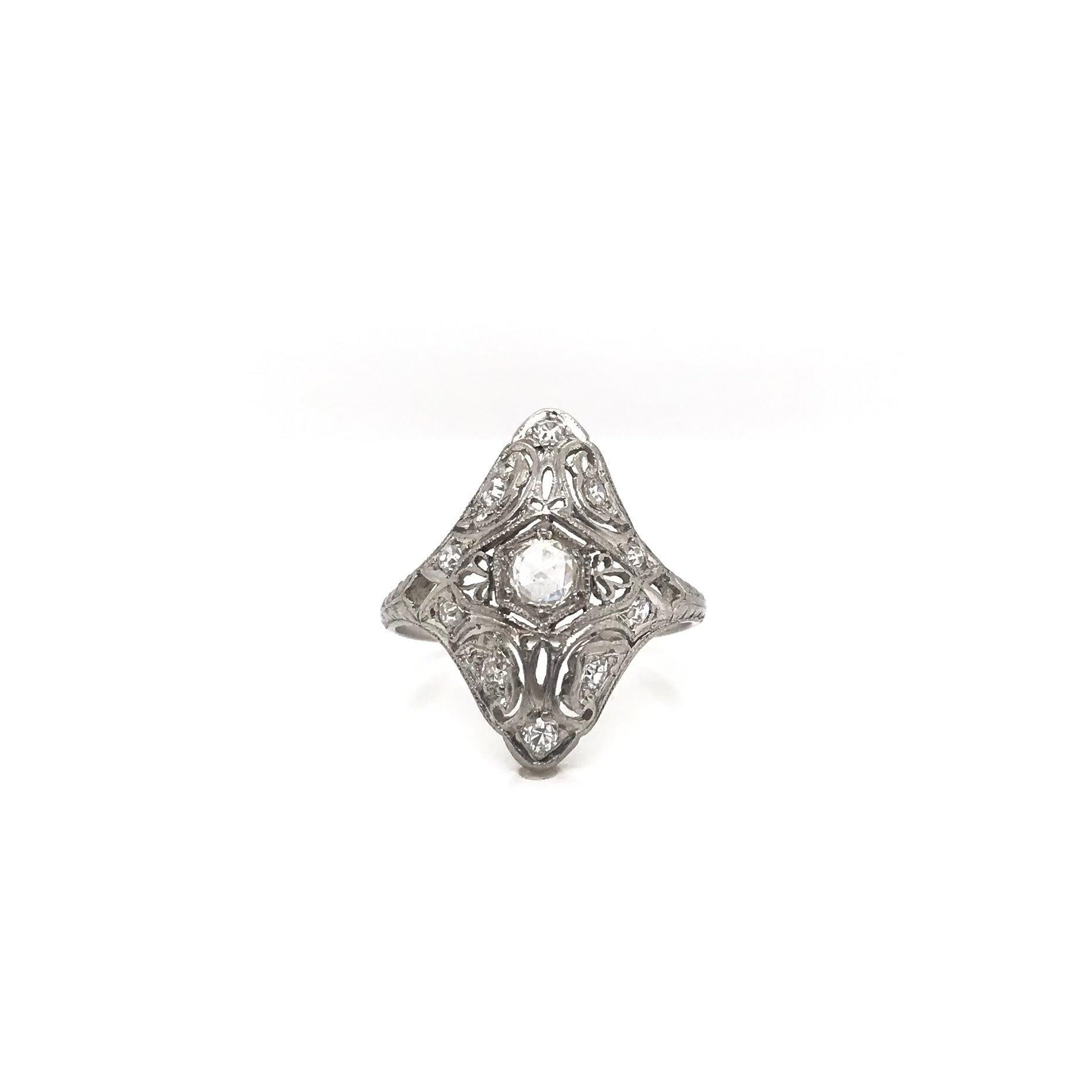 This antique diamond ring was handcrafted sometime during the Edwardian design period (1900-1920). The platinum setting features intricate filigree, precise milgrain accents, and beautiful hand engravings. The center diamond is an antique rose cut