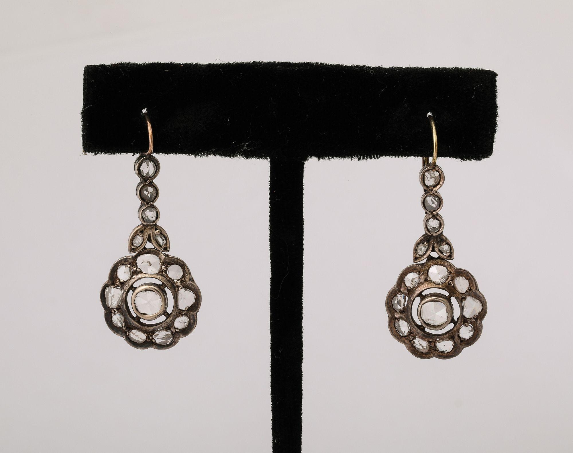 These charming Edwardian rose diamond floral design earrings haul a center diamond (bezel set) with smaller diamonds in a scallop design , suspended from 3 diamond and leaf set in 18k white gold.