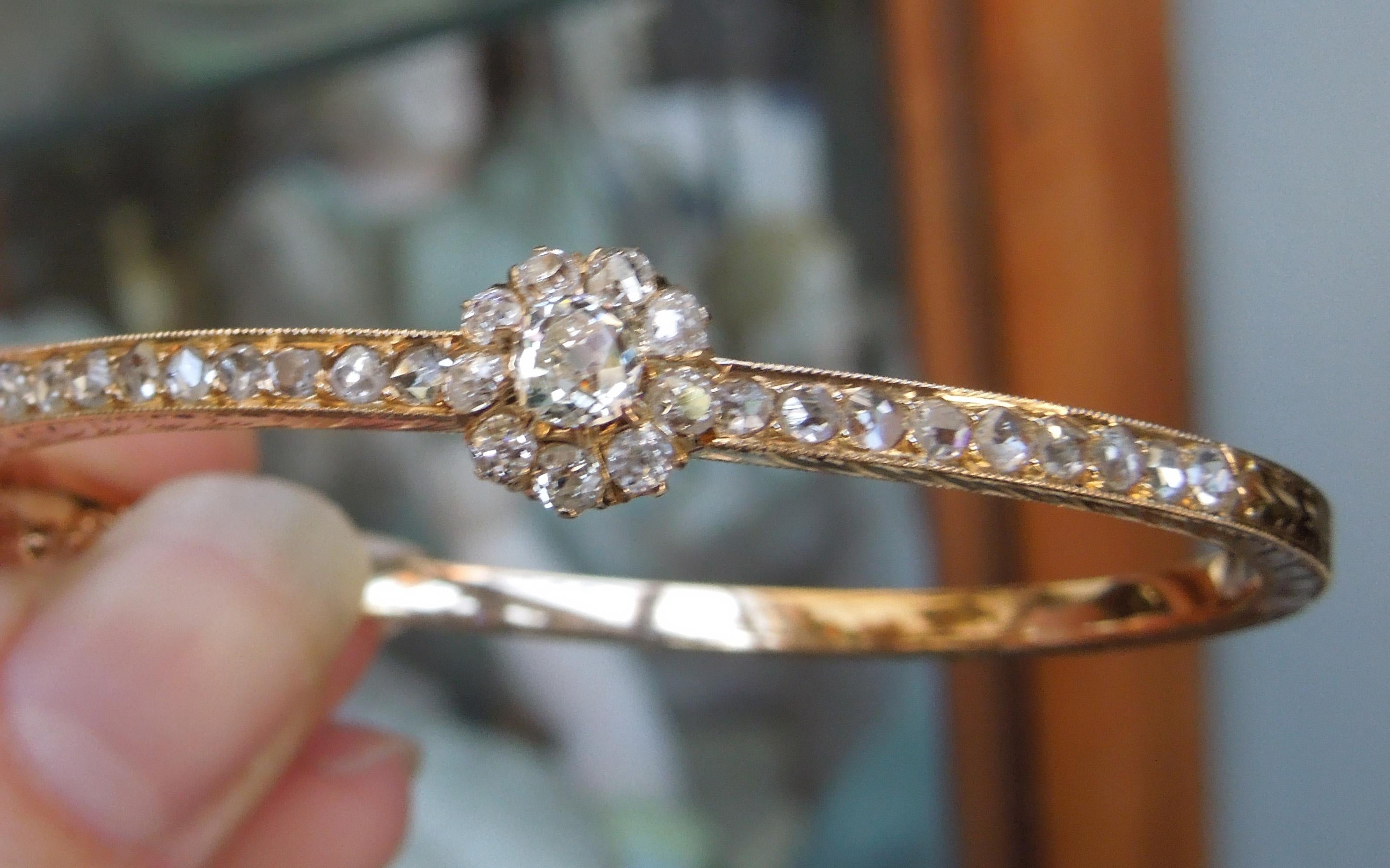 This Period Edwardian 14KT Rose Gold bangle is accented with exceptionally detailed Hand Engraving with a total of 28 Nearly Flawless to Slightly Included Old Round European cuts totaling approximately 2.60 carats ranging from H-I Color & VVS2-SI1