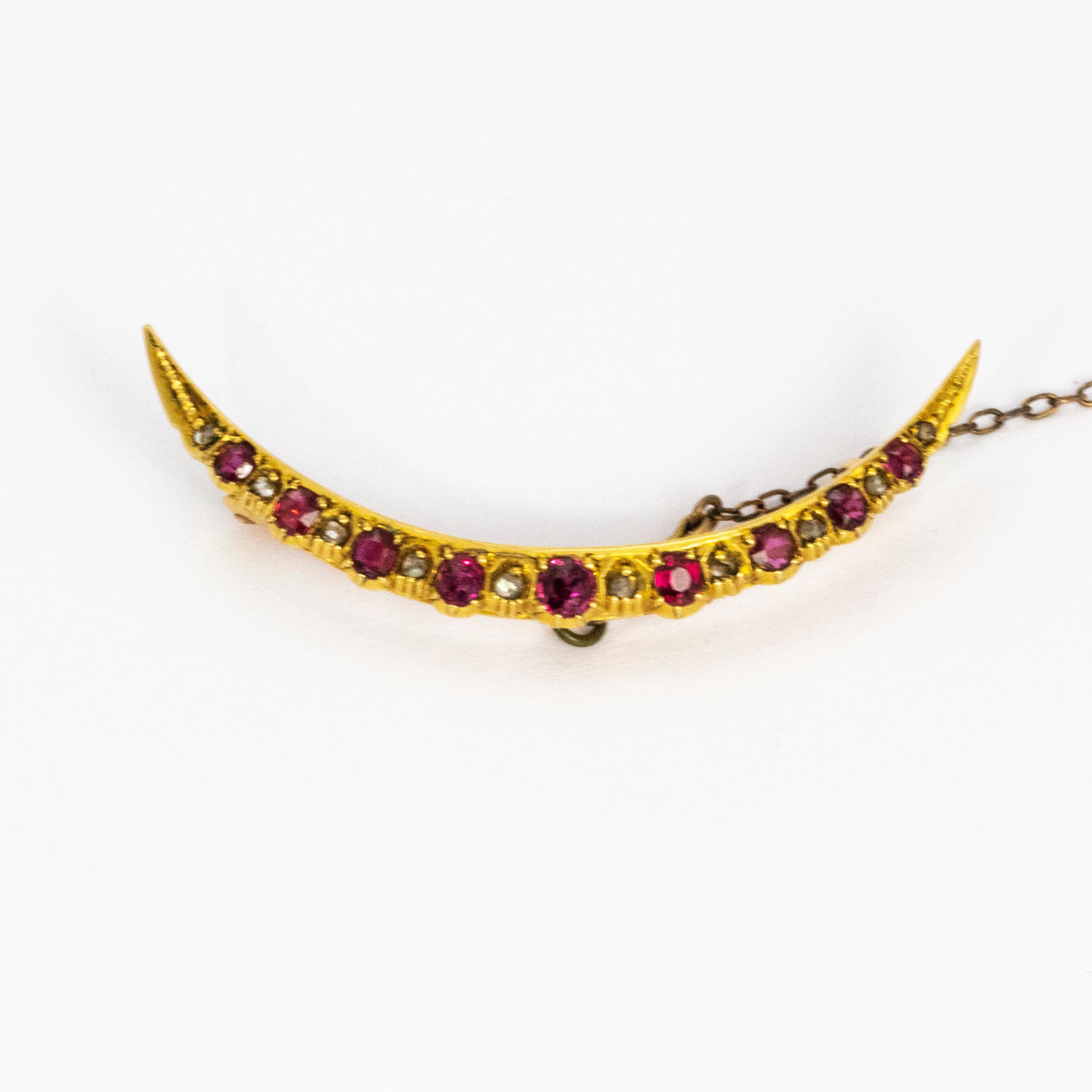 Gorgeous curved half moon 15ct gold brooch holding nine sparkling rubies and ten delicate diamonds.
