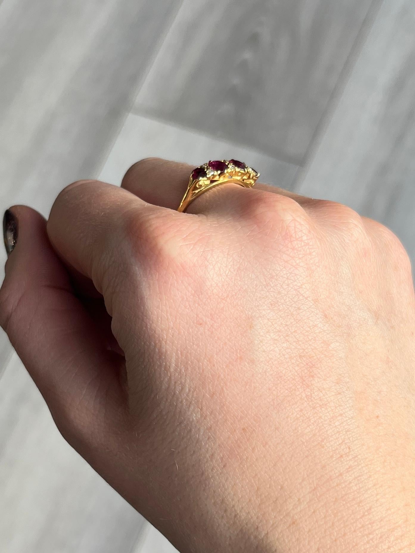 Set in this glossy 18ct gold ring are four rubies totalling 80pts and six rose cut diamonds. The stones are set flush within the decorative scroll setting. 

Ring Size: O 1/2 or 7 1/2 
Head Width: 5mm
Height Off Finger: 4mm

Weight: 3.1g