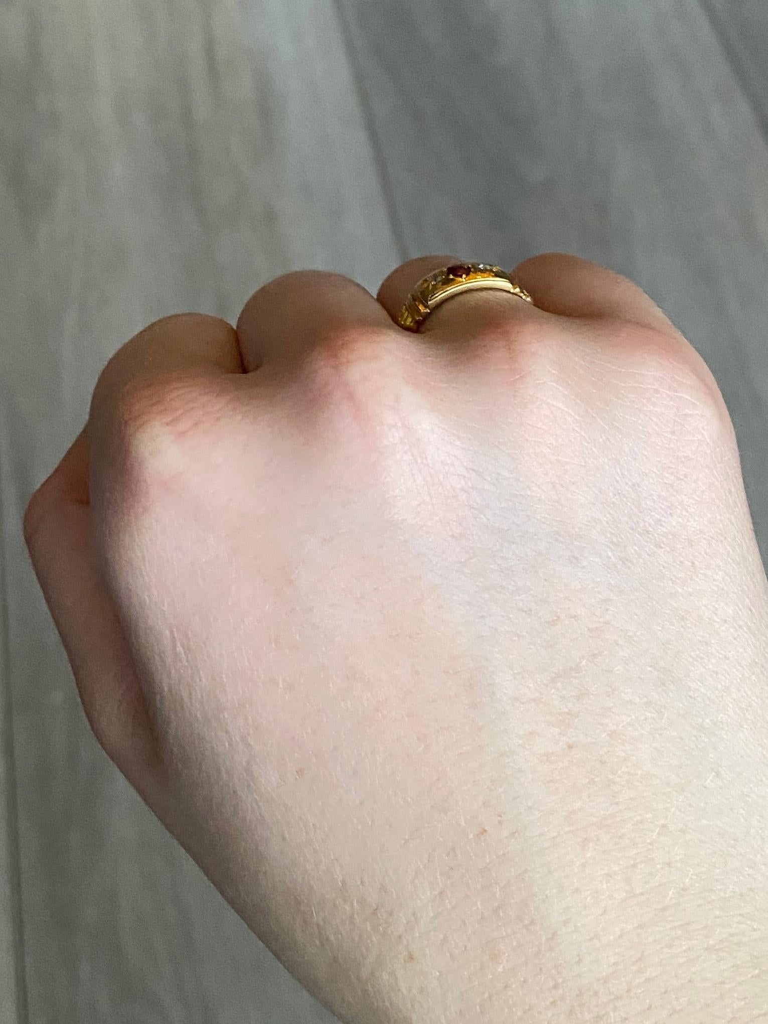 This glossy 18ct gold band holds a 15pt ruby at the centre and either side there is a 5pt ruby.  Made in Birmingham 1903 England. 

Ring Size: K 1/2 or 5 1/2 
Band Width: 8mm

Weight: 3.7g