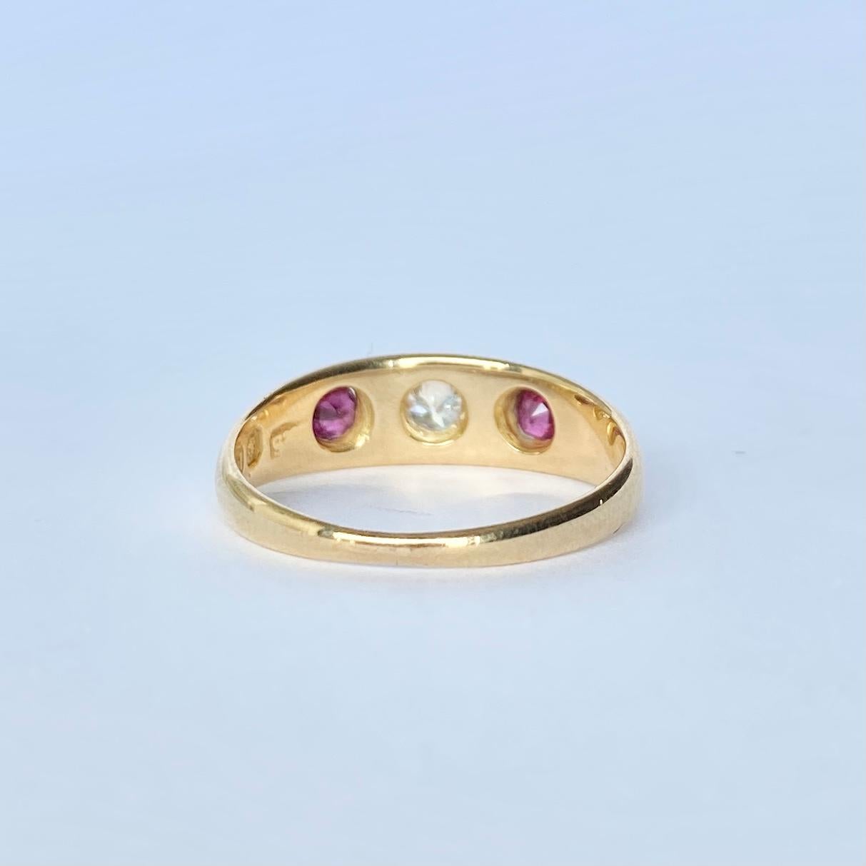 The central diamond in this glossy 18ct gold band measures 15pts and is set in a star setting. The rubies that sit either side of this stone measure 10pts and are held in flush claw settings. Fully hallmarked Chester 1890.

Ring Size: M 1/2 or 6 1/2