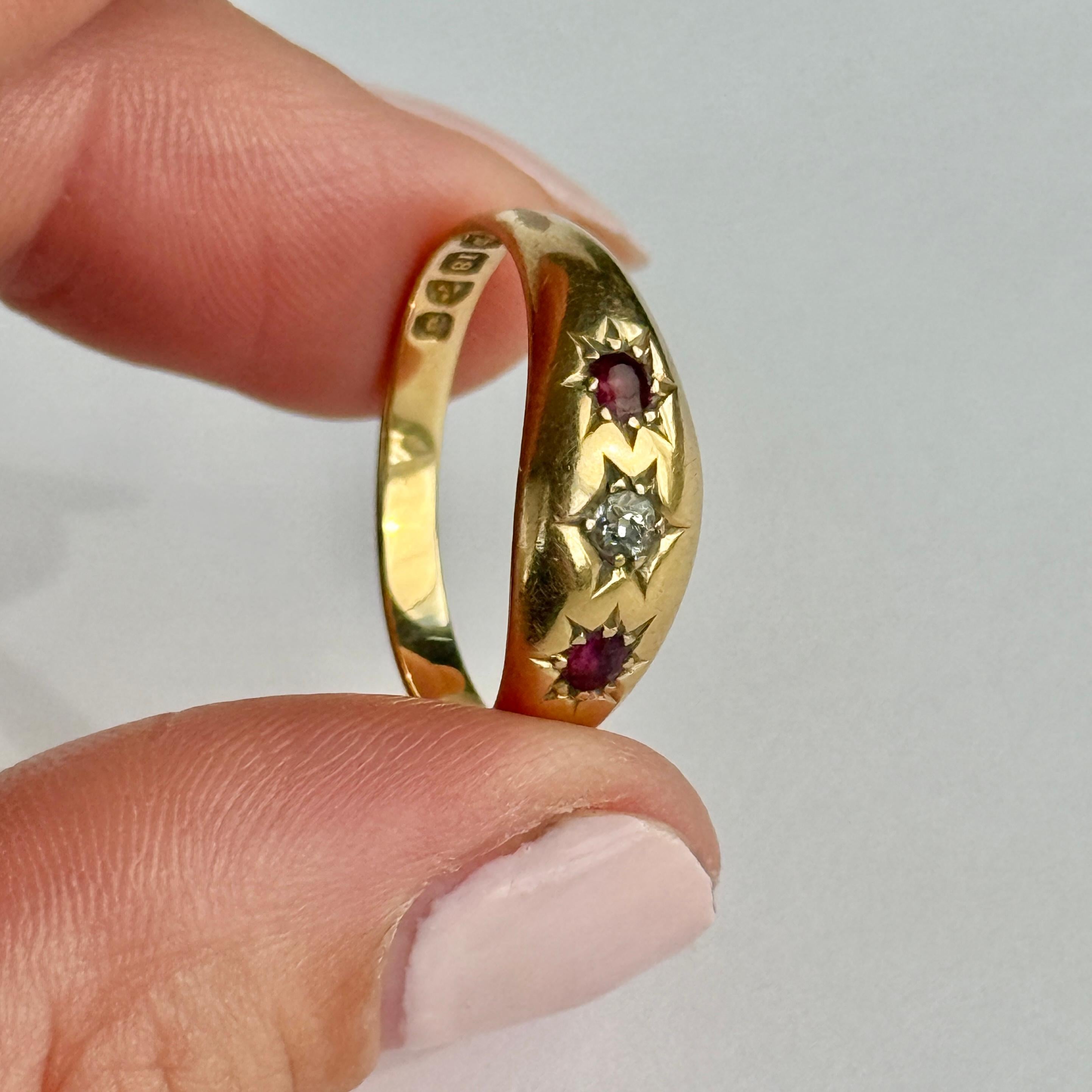 Der zentrale Diamant in diesem glänzenden 18-karätigen Goldband misst 10 Pence und ist in einer Sternfassung gefasst. Die Rubine, die auf beiden Seiten dieses Steins sitzen, messen jeweils 7 Pence. Gepunzt: Chester 1903.

Ringgröße: R oder 8 1/2