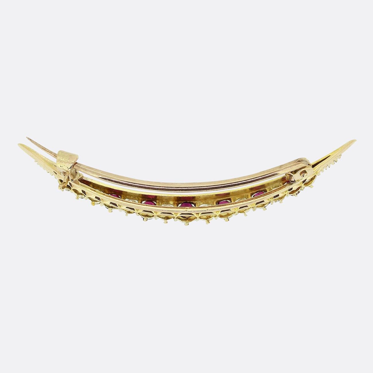Here we we have a classic crescent brooch dating back to the Edwardian era. This antique piece has been crafted from 18ct yellow gold into the shape of a moon crescent which plays host to a single row of alternating rubies and diamonds. The rubies
