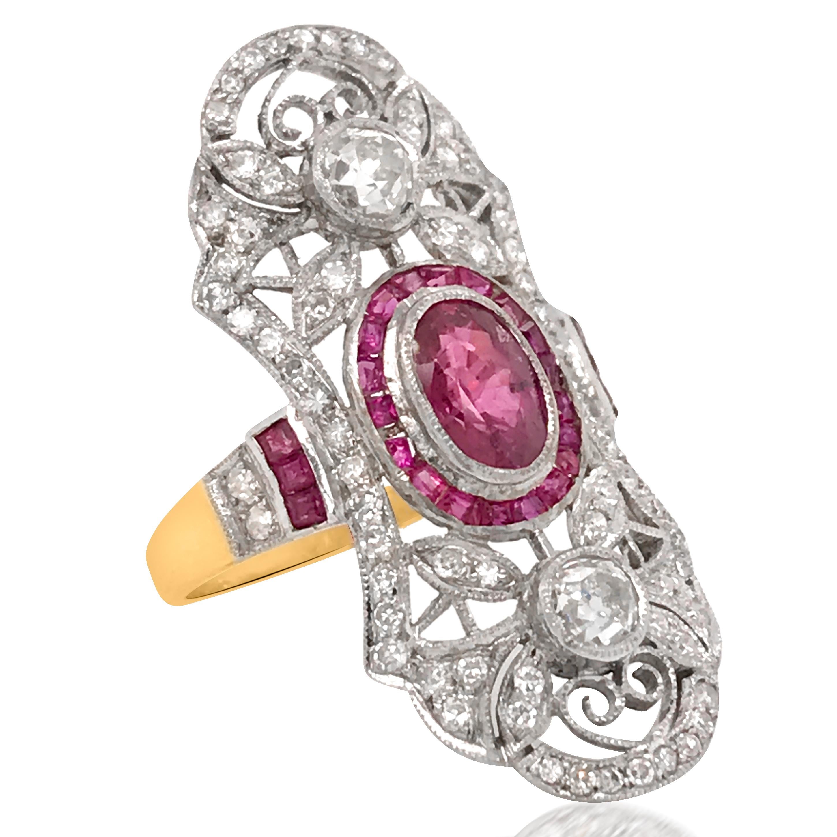 This Edwardian ruby and diamond ring is crafted in platinum, weighing 5.44 grams and in size 6.5. The waisted oval of pierced and millegrained platinum with foliate and scroll motifs set with old European cut and old Mind cut diamonds, approx. 1.38