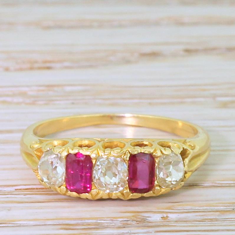 Oh my this is stunning. A trilogy of well matched, bright, clean and lively cushion shaped old mine cut diamonds are inter-spaced with two bright bright pinkish red rubies. Beautiful heart-shaped detailing in the gallery leads to a fine 18k yellow