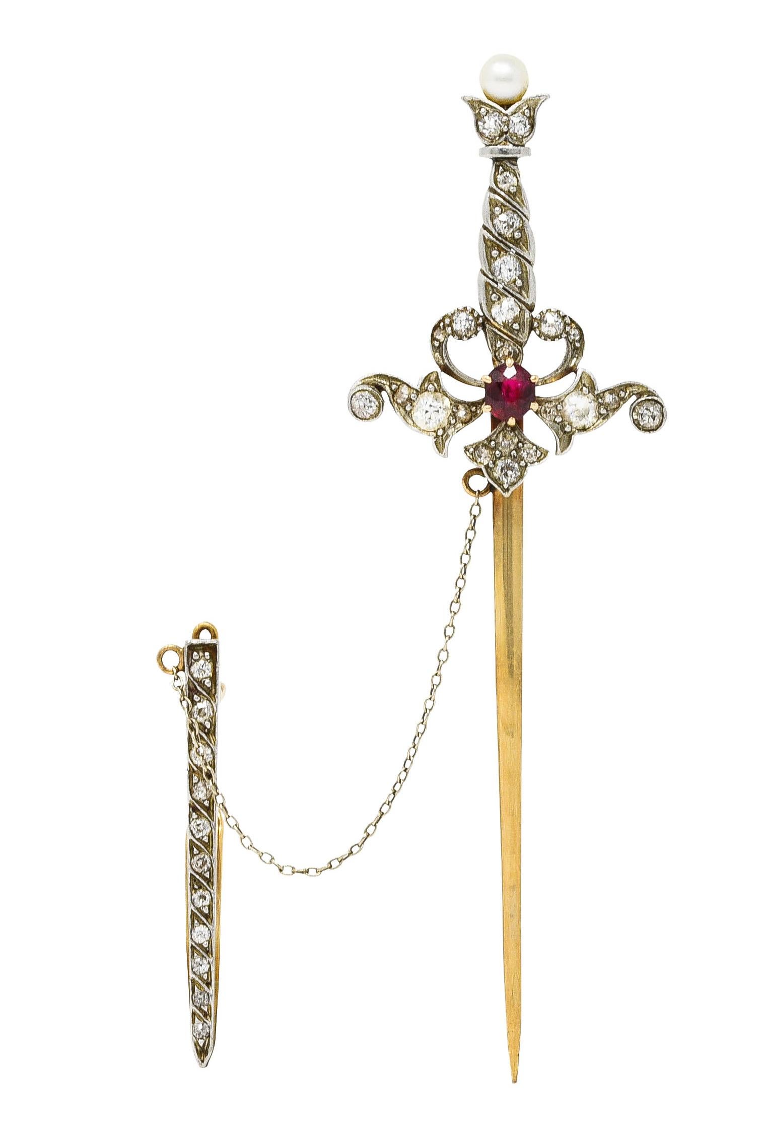 Pendant brooch is designed as a jabot style sword that can be removed from its scabbard to reveal a gold blade. Featuring a cushion cut ruby weighing approximately 0.40 carat - bright red. Hilt and scabbard are set with old mine and old European cut