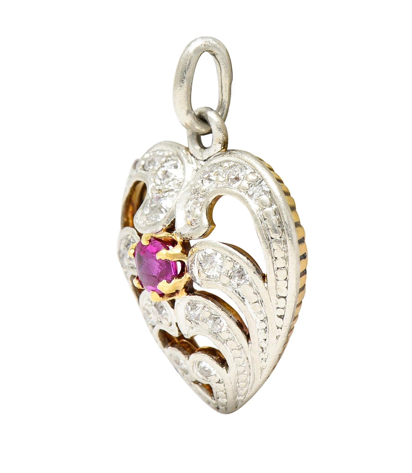 Charm is designed as a scrolling heart motif with platinum bead detailing. Centering a cushion shaped buff top ruby weighing approximately 0.20 carat - purple/red in color. Surrounded by old European cut diamonds weighing in total approximately 0.25
