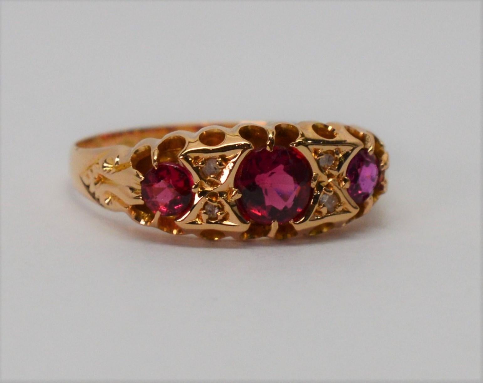 Three vibrant rose cut rubies are the feature of this fine Edwardian period eighteen karat 18k yellow gold ring. It's beautiful antique setting includes four .01 carat diamonds accents that further complement the colorful hand cut ruby gemstones,