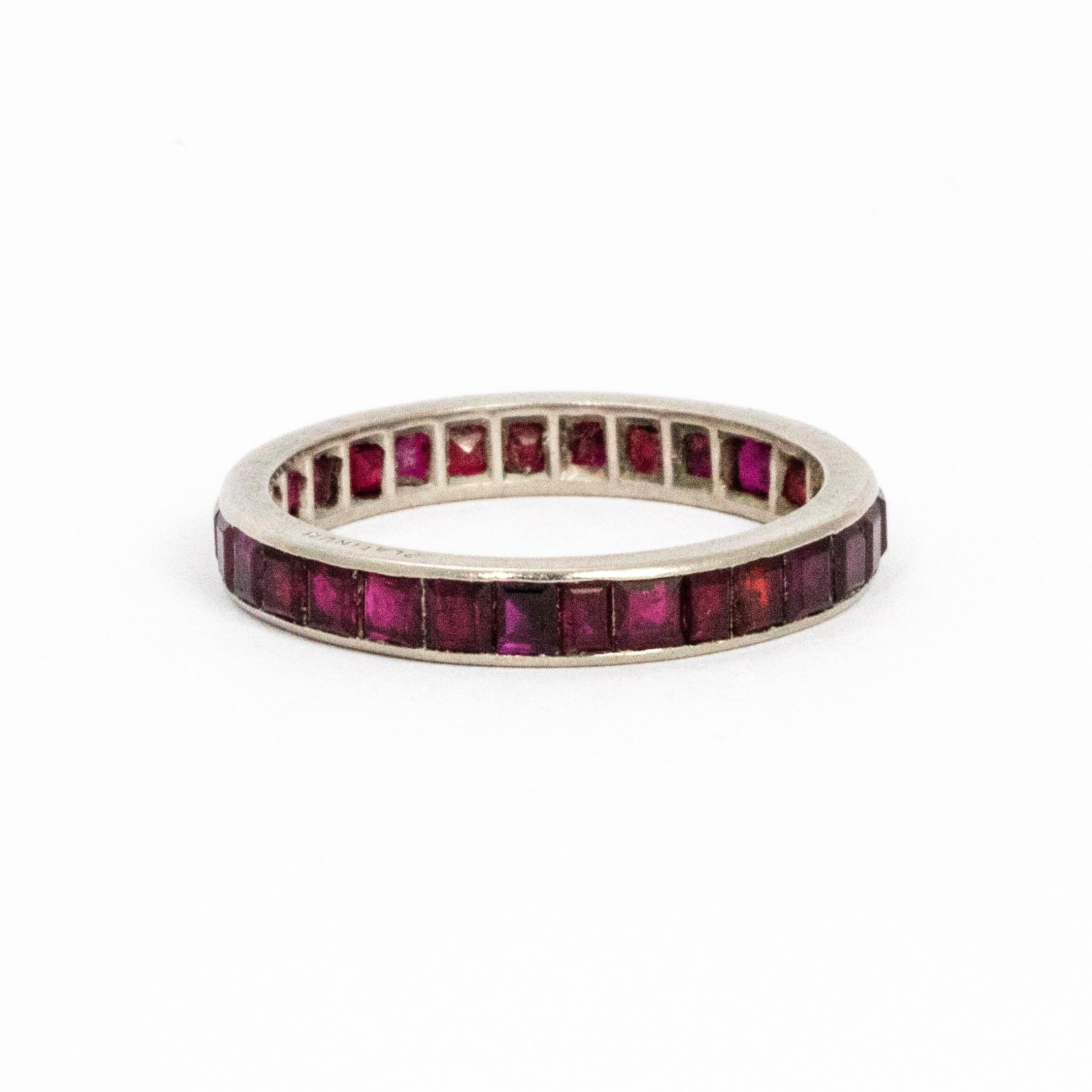Glossy platinum eternity band holding a halo of glistening rubies.

Ring Size: N 1/2 or 7