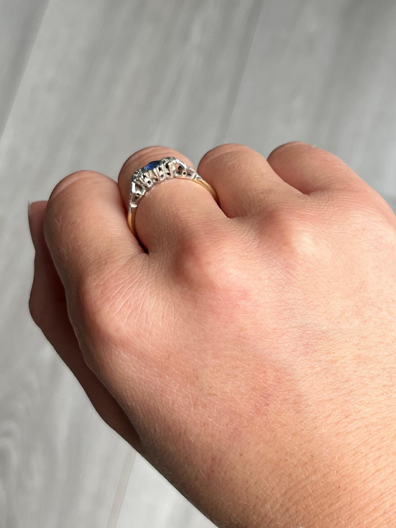 This stunning 18ct gold and platinum ring holds a central sapphire approximately 15pts in size and is of good blue colour. There is a diamond set either side of the centre stone each measuring approximately 2pts each. 

Ring Size: R or 8 3/4 
Height
