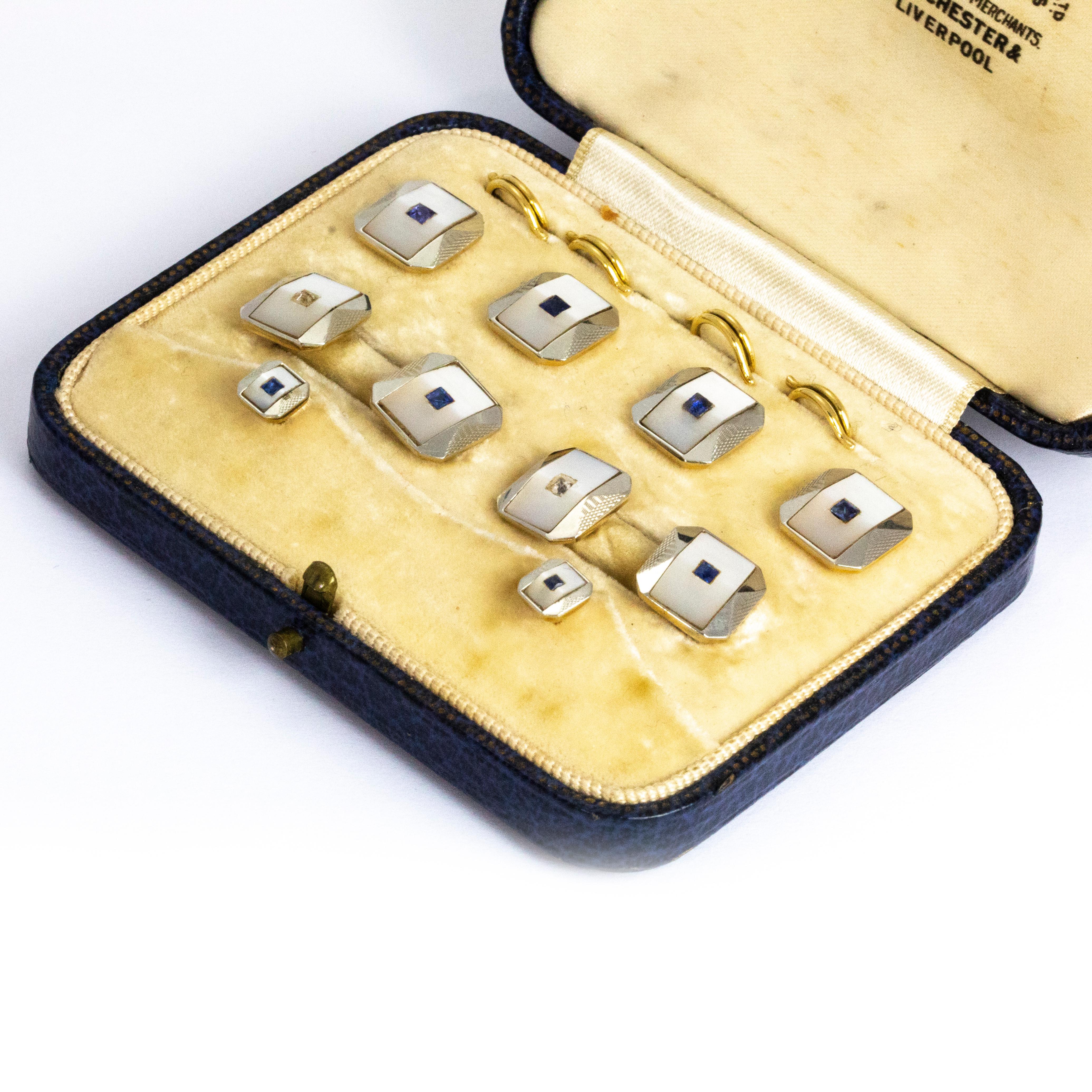 This stunning Edwardian cuff link and stud set come complete in their original fitted box. Each link or stud feature a mother of pearl panel with either a square cut diamond or sapphire at the centre. These are modelled out of 9ct and 18ct Gold and