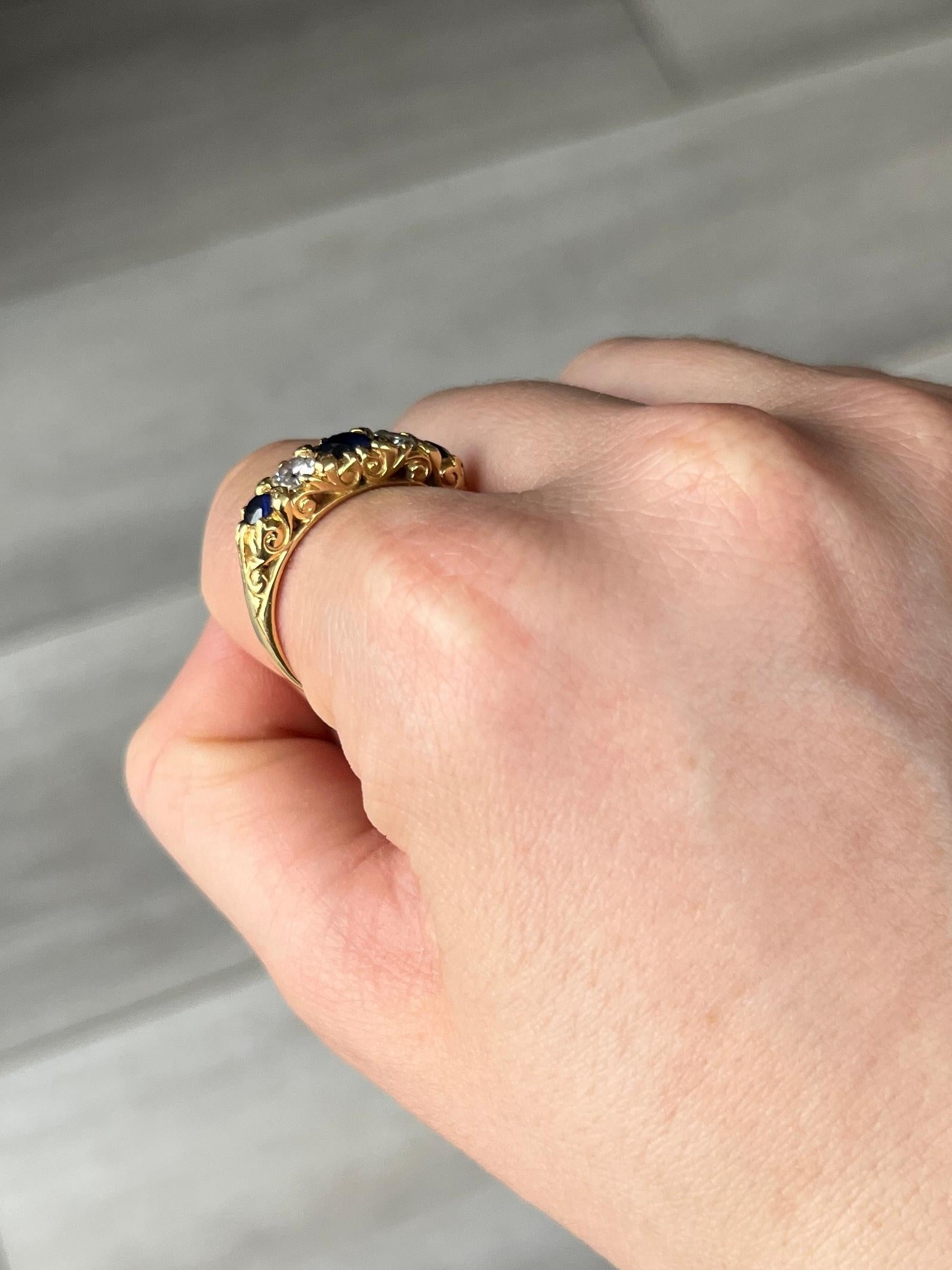 Cette magnifique bague contient trois saphirs d'un bleu profond. Le saphir central mesure 40pts et les saphirs extérieurs 15pts chacun. Les diamants entre ces pierres bleues mesurent 30pts chacun. Modelé en or 18 carats.

Taille de la bague : T ou 9