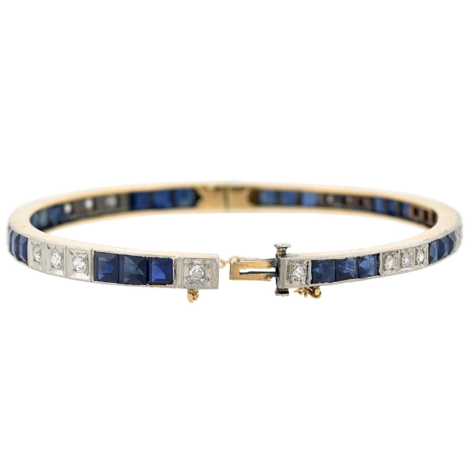 A beautiful sapphire and diamond bracelet from the Edwardian (ca1910s) era! Crafted in 14kt gold, the bangle-style bracelet is topped in platinum for a lovely 2-tone effect. Lining the bracelet's surface are a mix of 9 old Mine Cut diamonds on one