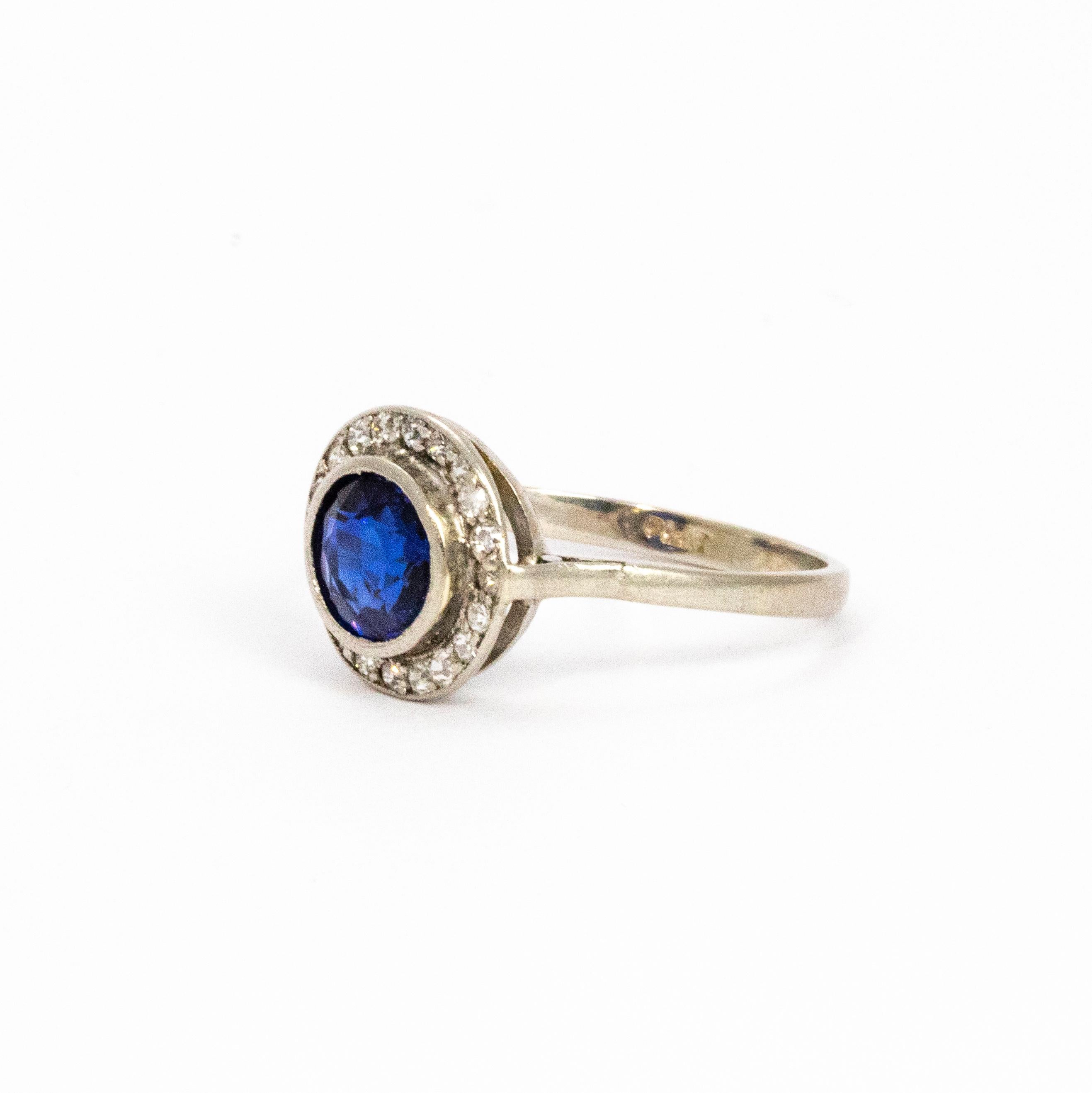 A large glistening sapphire surrounded by a halo of sparkling diamonds all set in platinum.

Ring Size: L 1/2 or 6