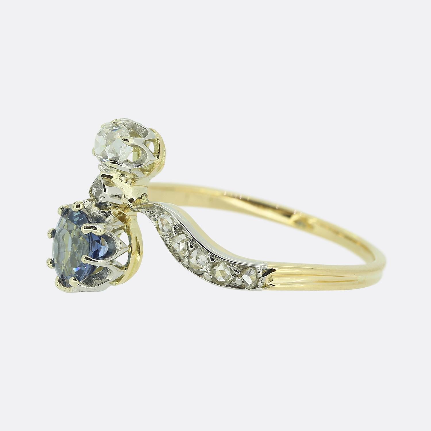 Here we have a charming Edwardian ring showcasing a sapphire and diamond two-stone design with rose cut diamond accents at the band. This piece has been crafted from a warm 18ct yellow gold with a gorgeous blue sapphire set below a round faceted old