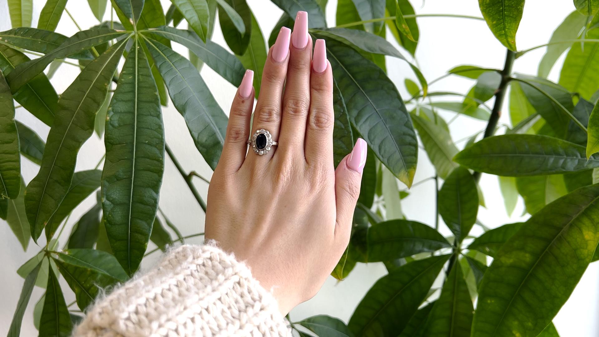 Ein Edwardian Saphir Diamant 14k Weißgold Cluster Ring. Mit einem ovalen Saphir im Mischschliff mit einem Gewicht von etwa 1,50 Karat. Akzentuiert durch 14 Diamanten im alten europäischen Schliff und zwei Diamanten im Einzelschliff mit einem
