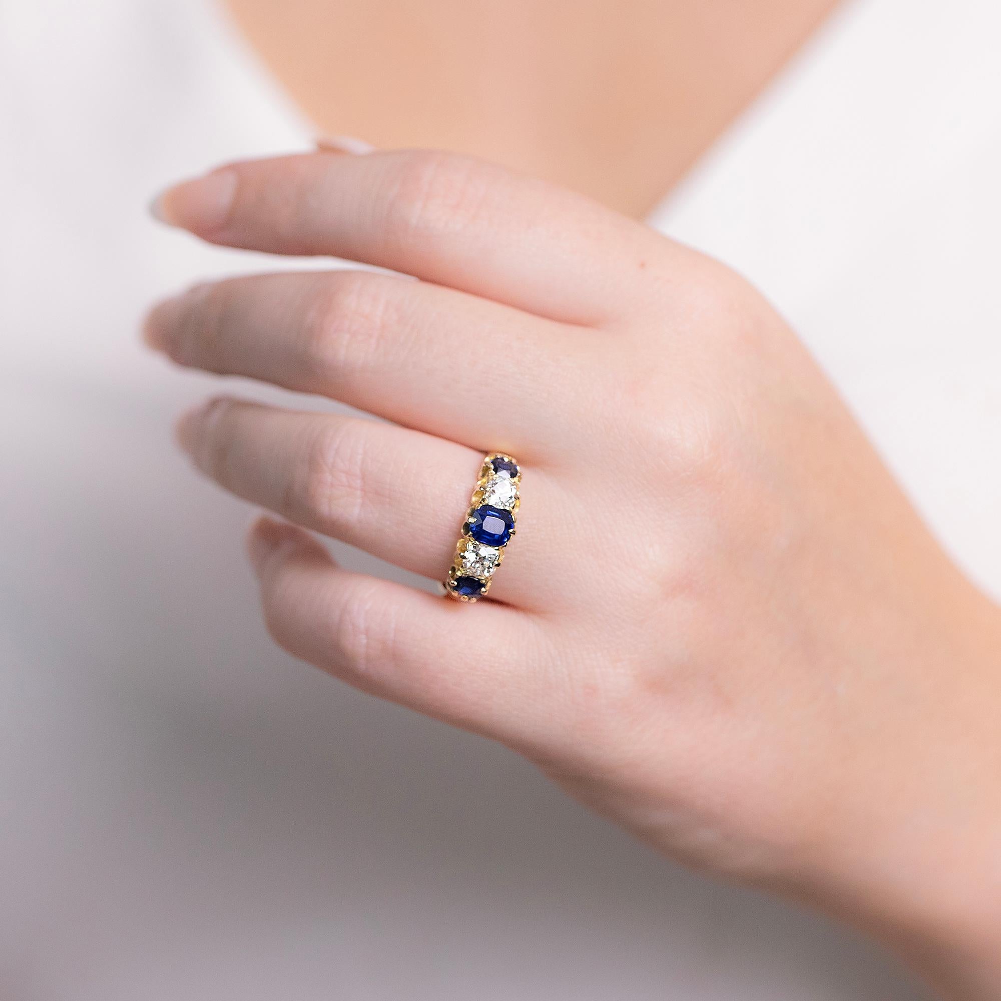 This beautiful restored Edwardian half hoop ring features three deep blue sapphire with two early European cut diamonds set in a stunning yellow gold scalloped setting.
The half hoop is a lovely style, sitting across the top of the finger, making